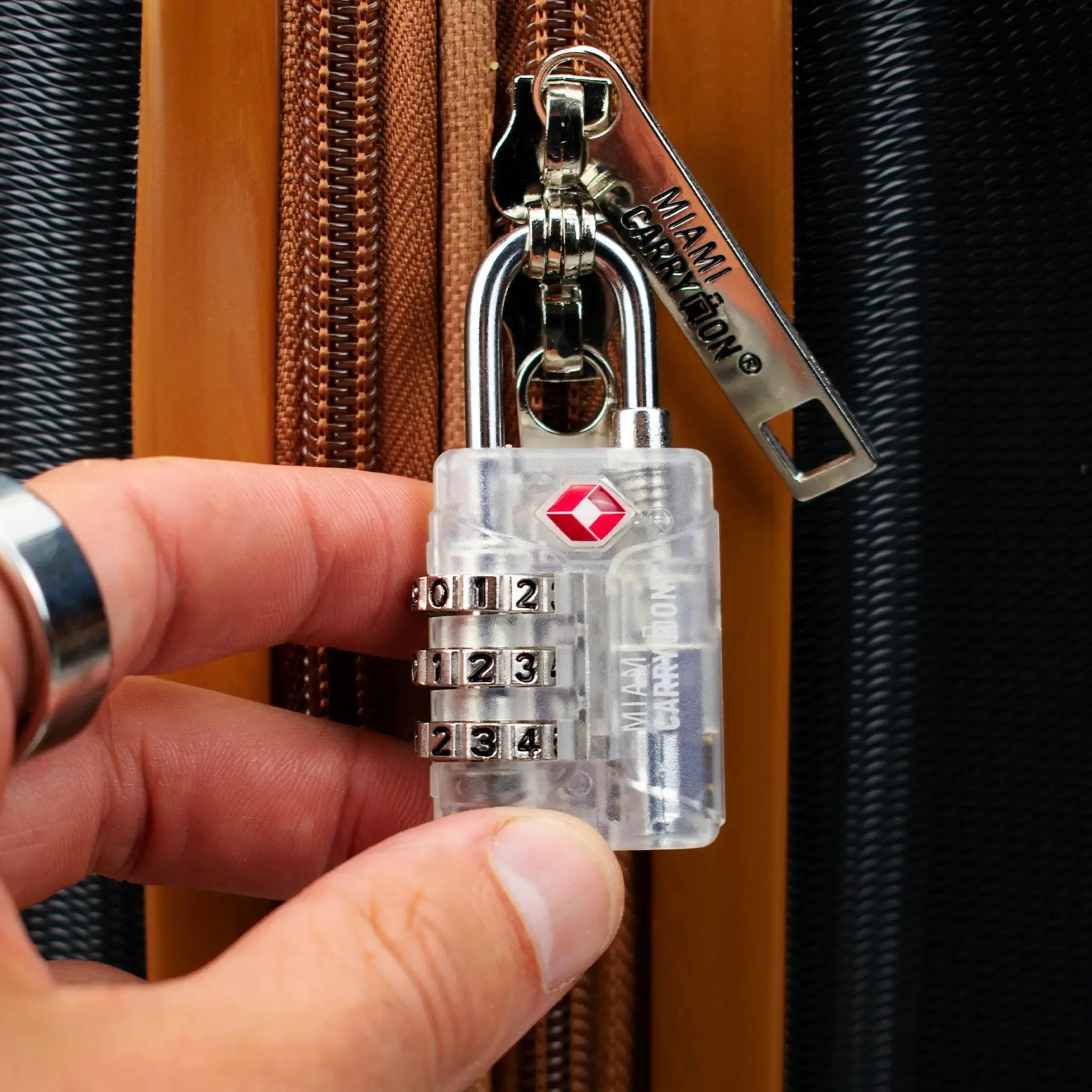 Clear combination lock held by a hand with a dark background