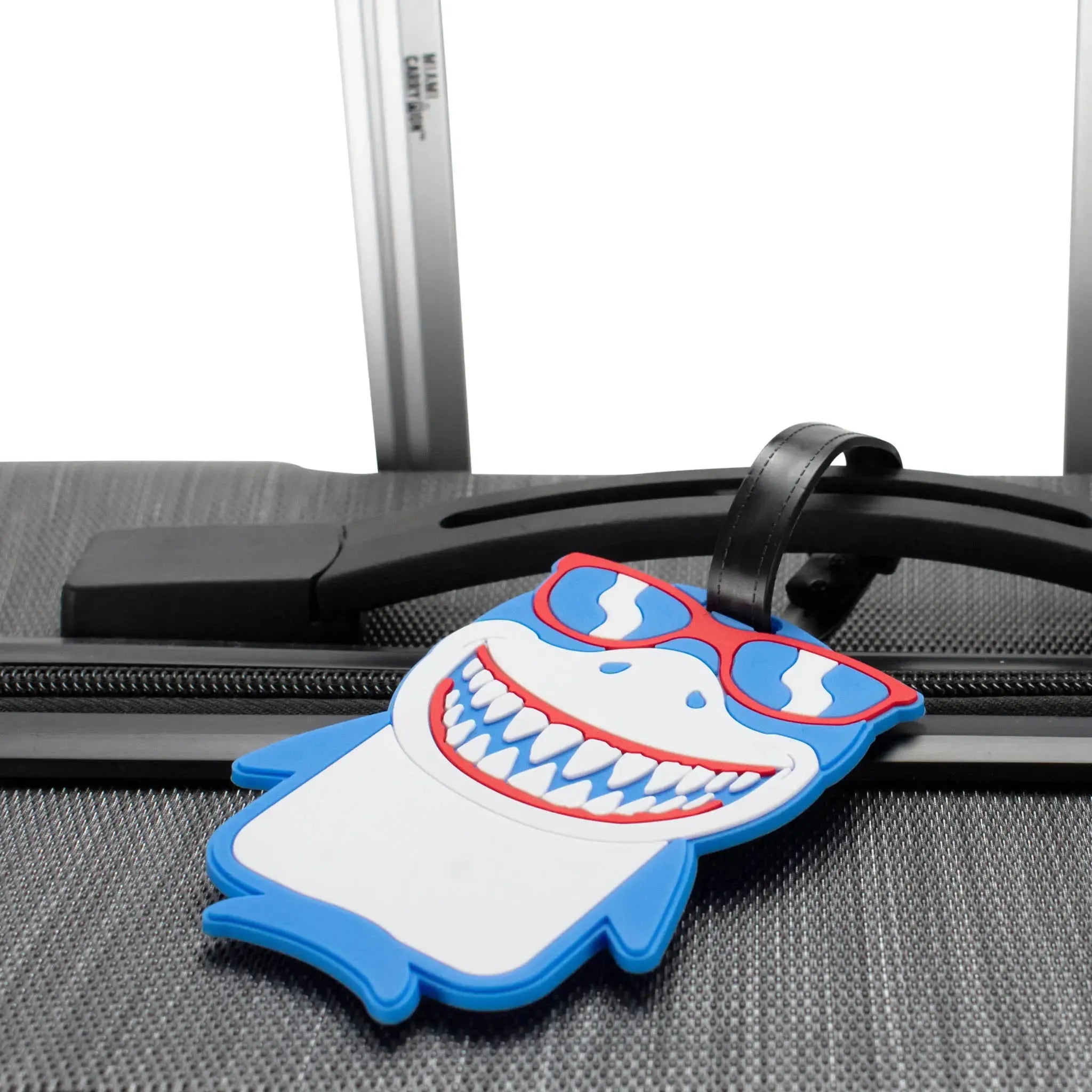 Shark-themed luggage tag attached to a suitcase handle