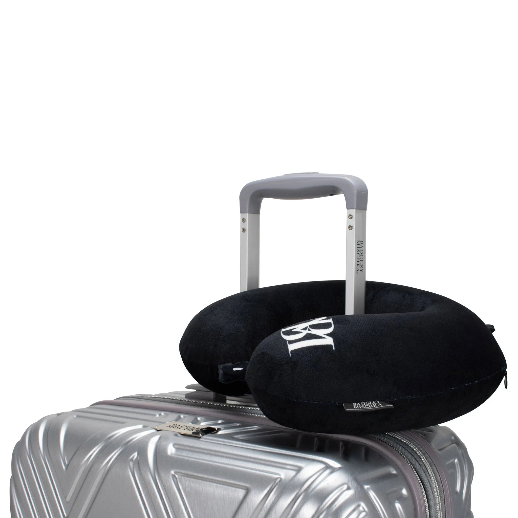 Black travel pillow on a silver suitcase with a white background