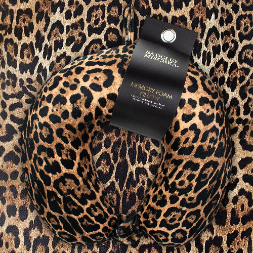 Leopard print memory foam pillow with a visible tag on a leopard print background