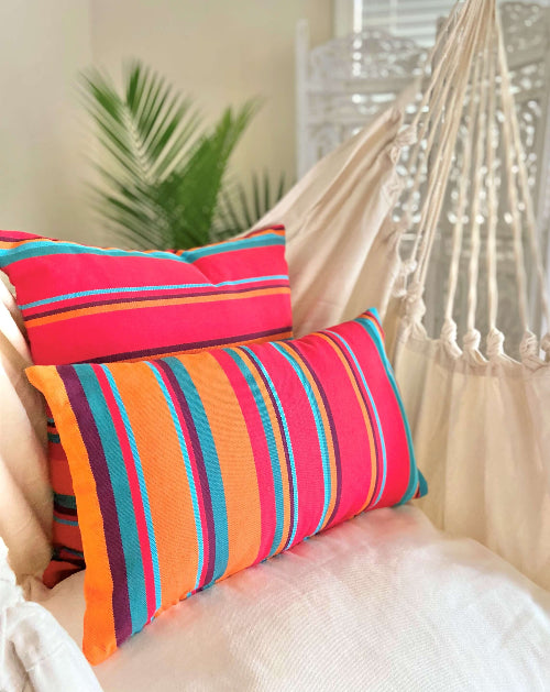 Colorful striped pillows on a hammock with a blurred indoor background