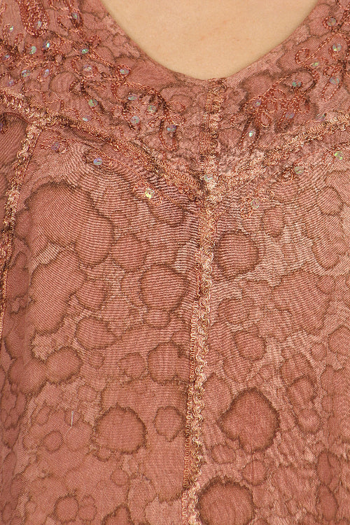 Close-up of a pink lace garment with intricate patterns and embellishments.