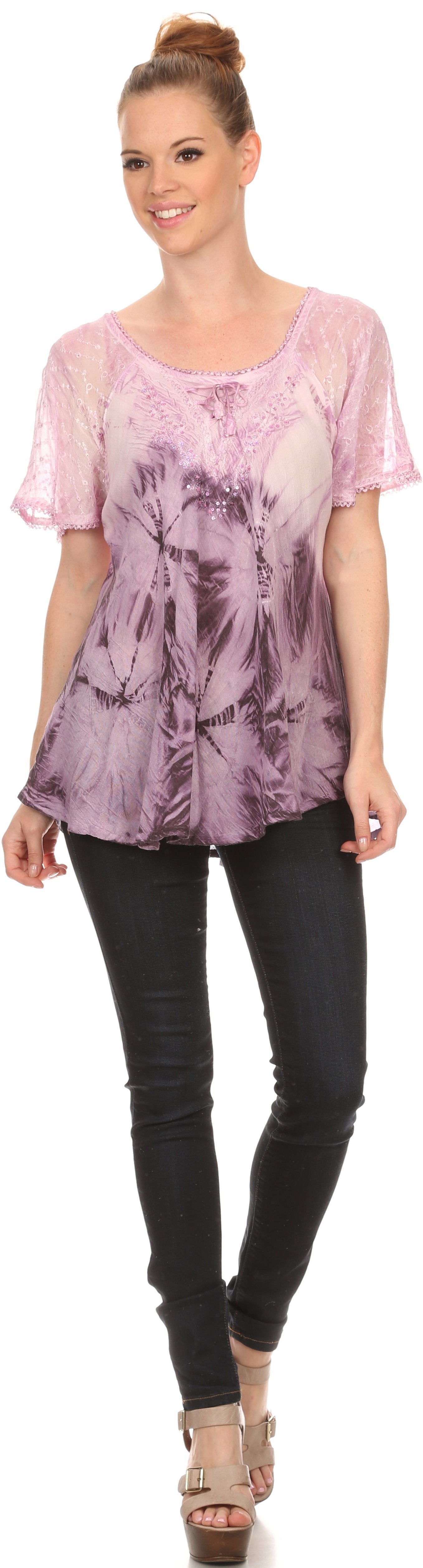 Woman wearing a pink tie-dye top and black pants on a white background