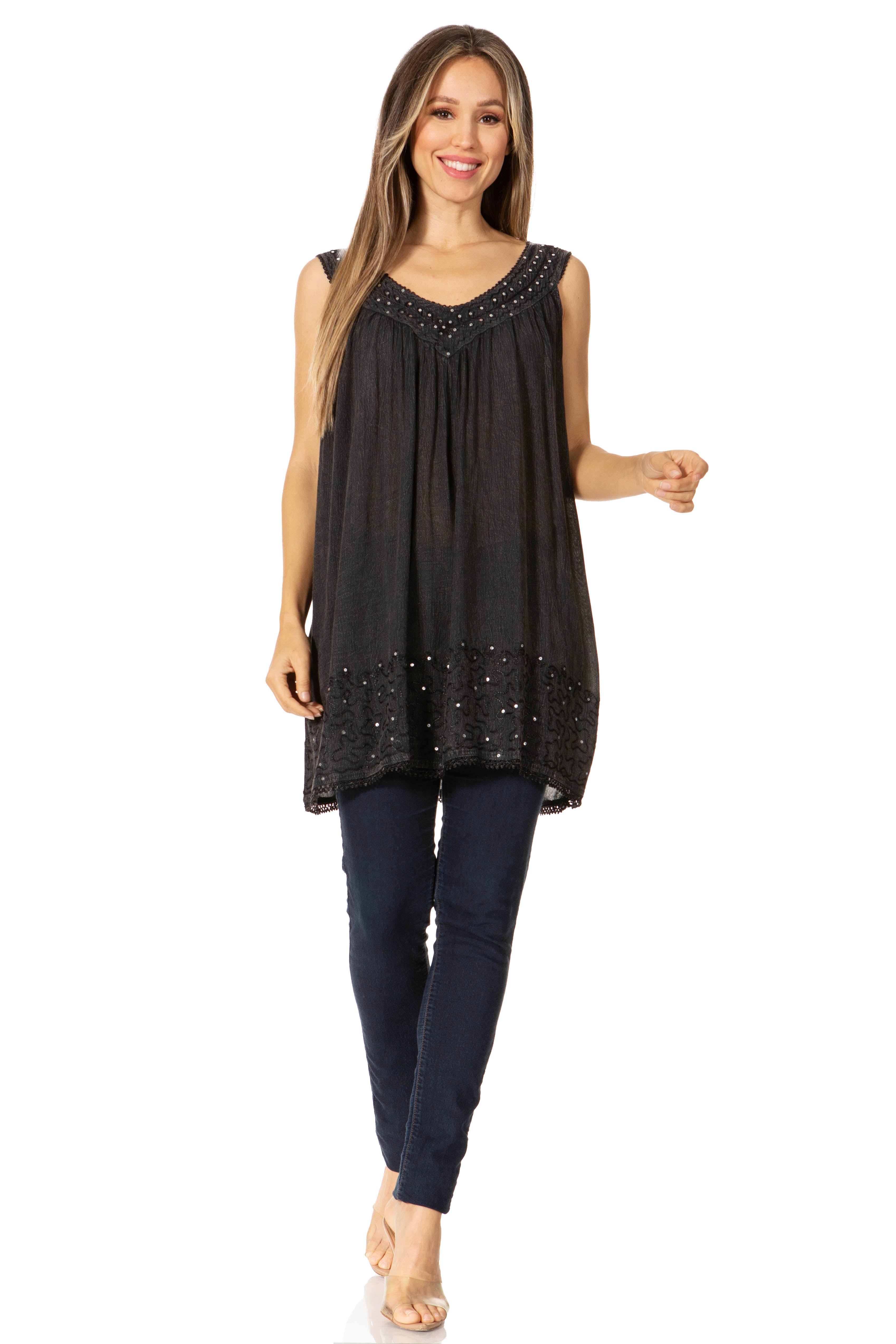 Woman wearing a black sleeveless top with bead details and dark jeans on a white background