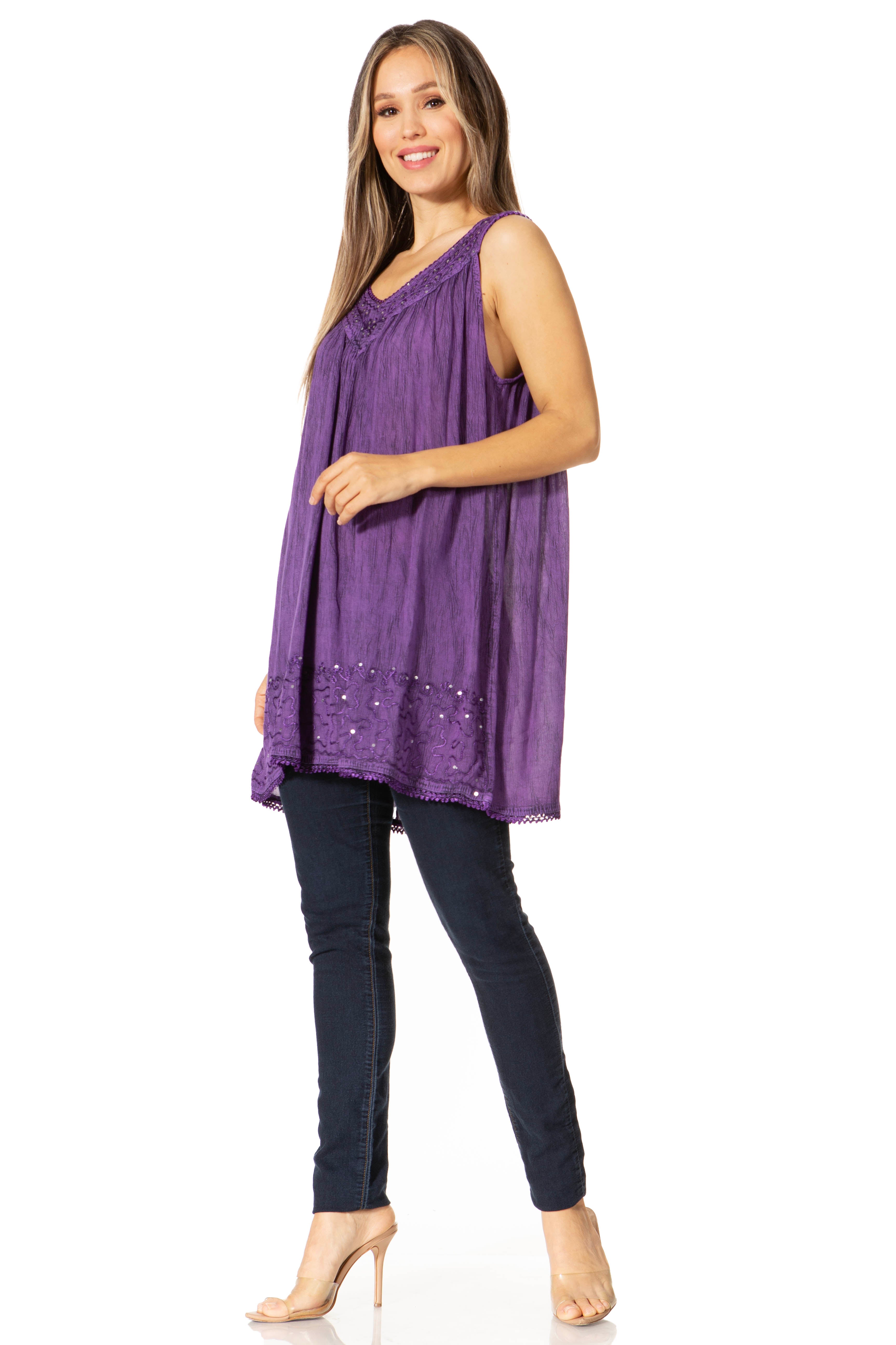 Woman wearing a purple sleeveless top and black pants on a white background