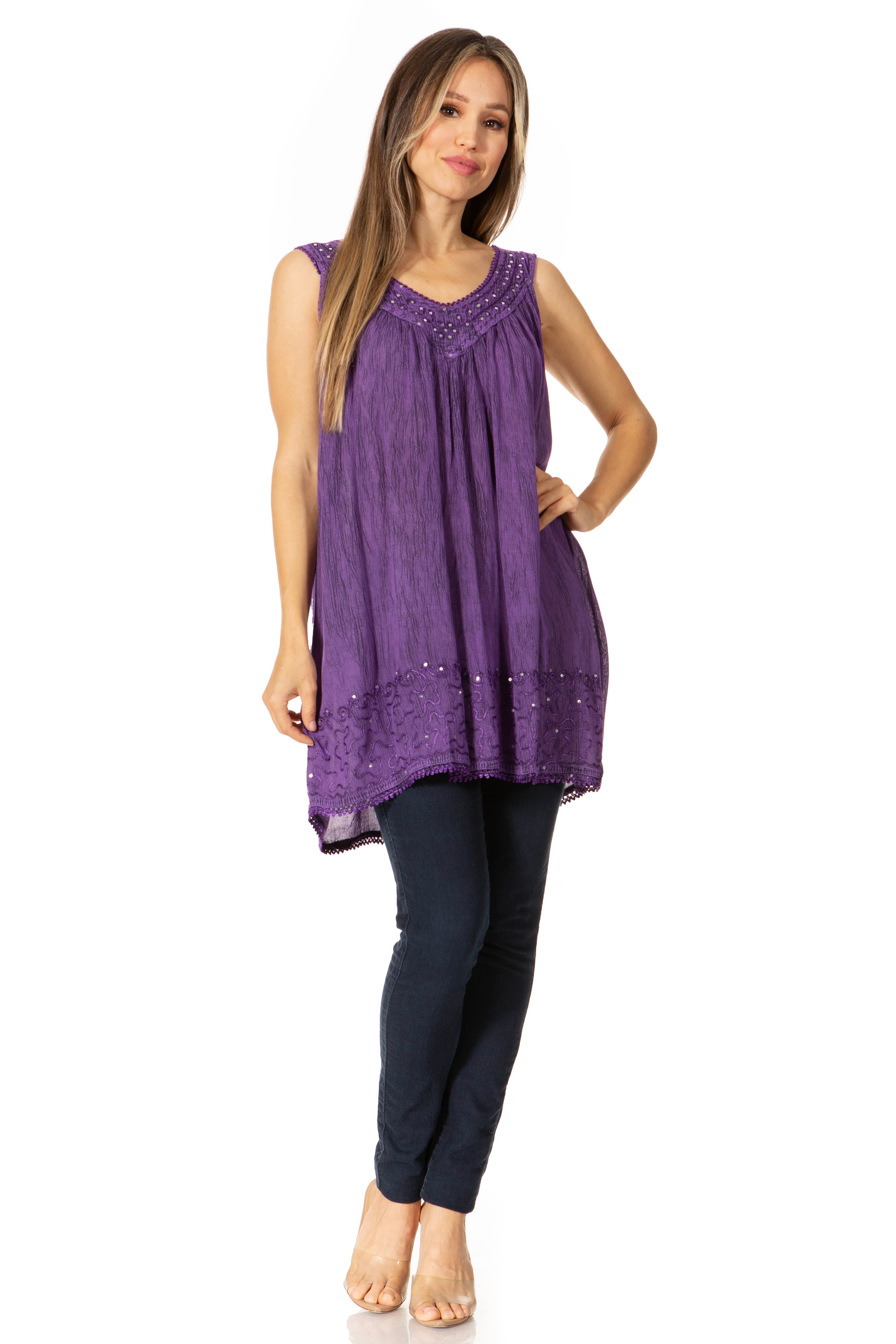 Woman wearing a purple sleeveless top and navy pants on a white background