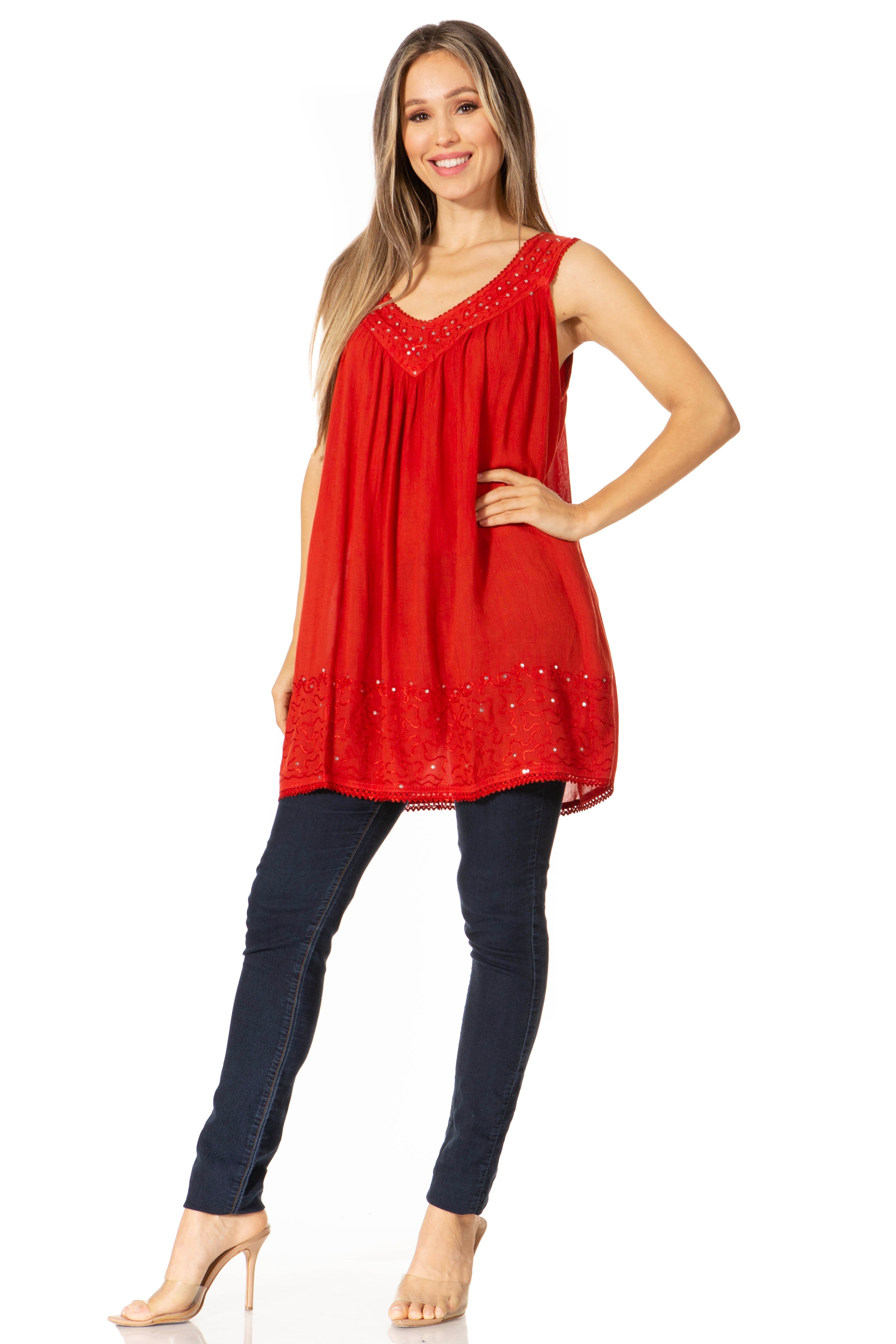 Woman wearing a red sleeveless top with beaded details and dark jeans on a white background