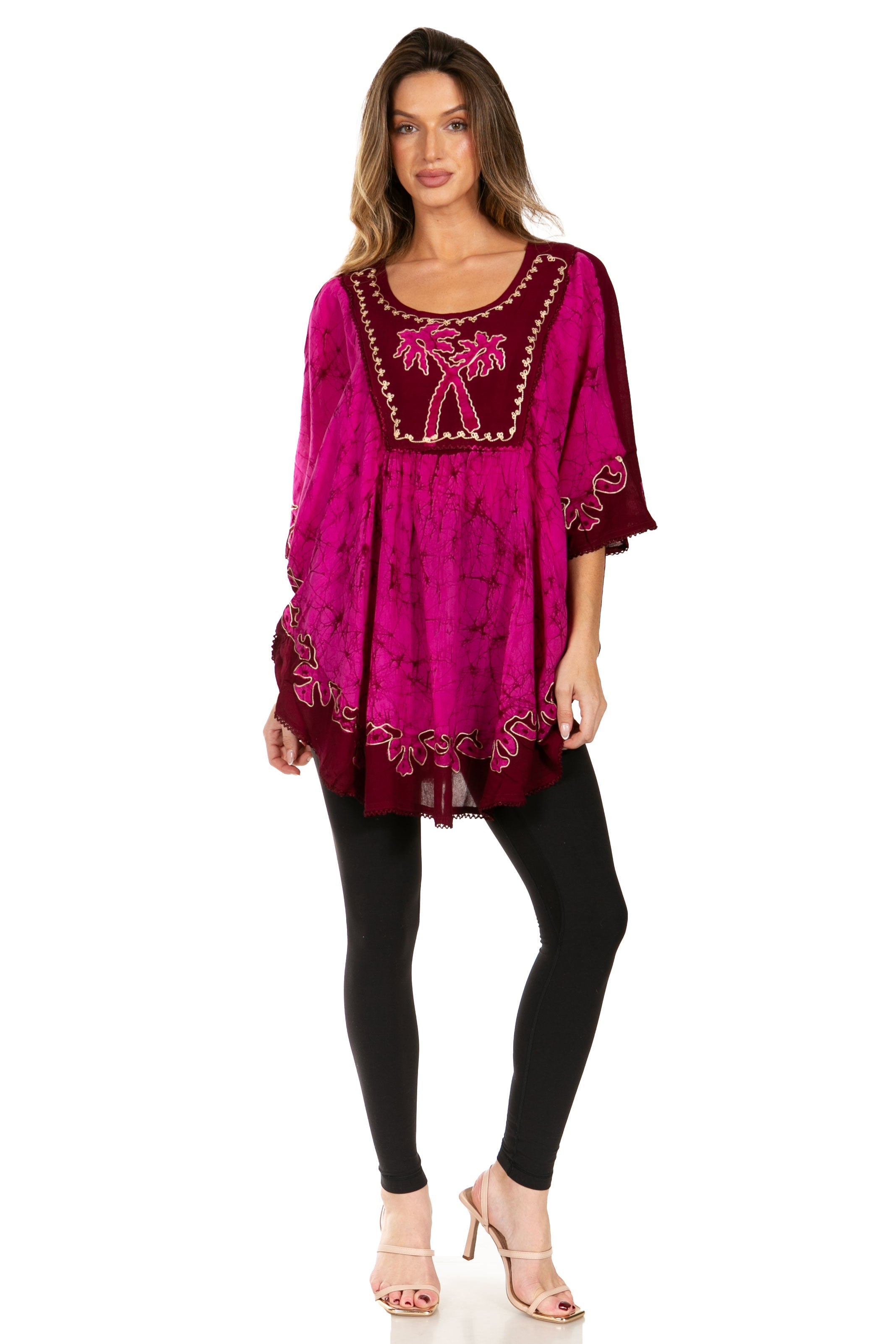 Woman wearing a magenta embroidered dress with black leggings on a white background