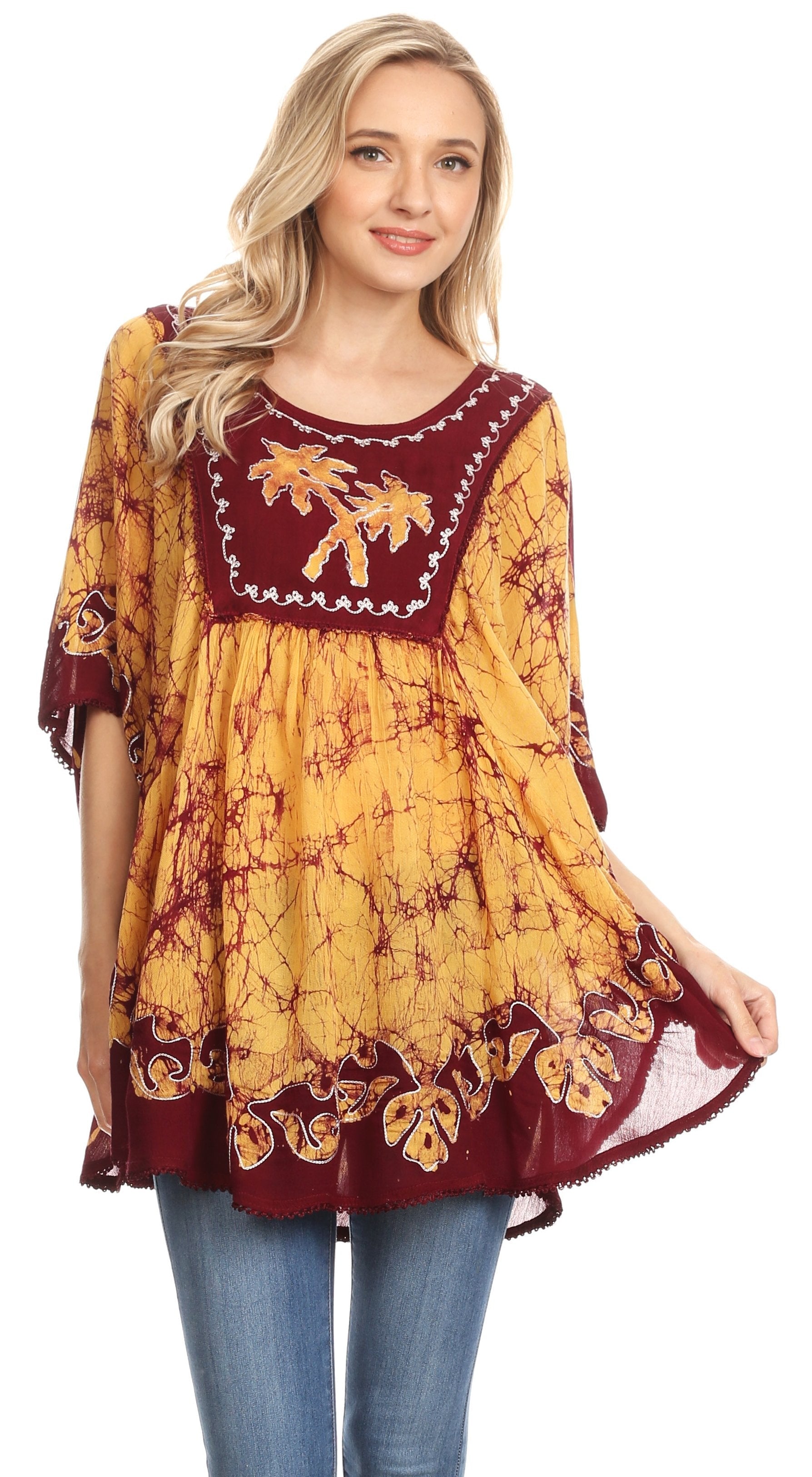 Woman wearing a yellow and red patterned dress with blue jeans on a white background