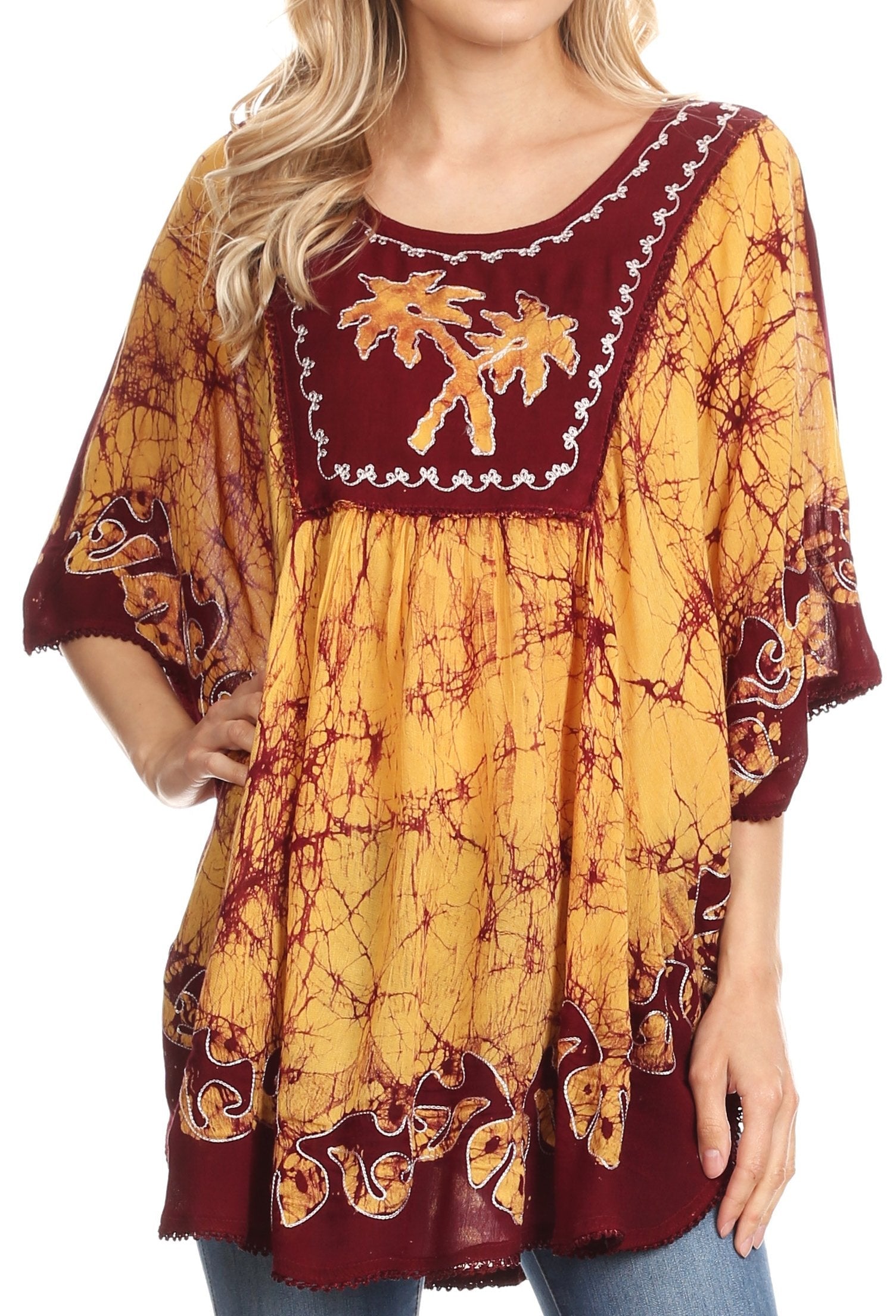 Woman wearing a yellow and maroon patterned dress with floral embroidery.