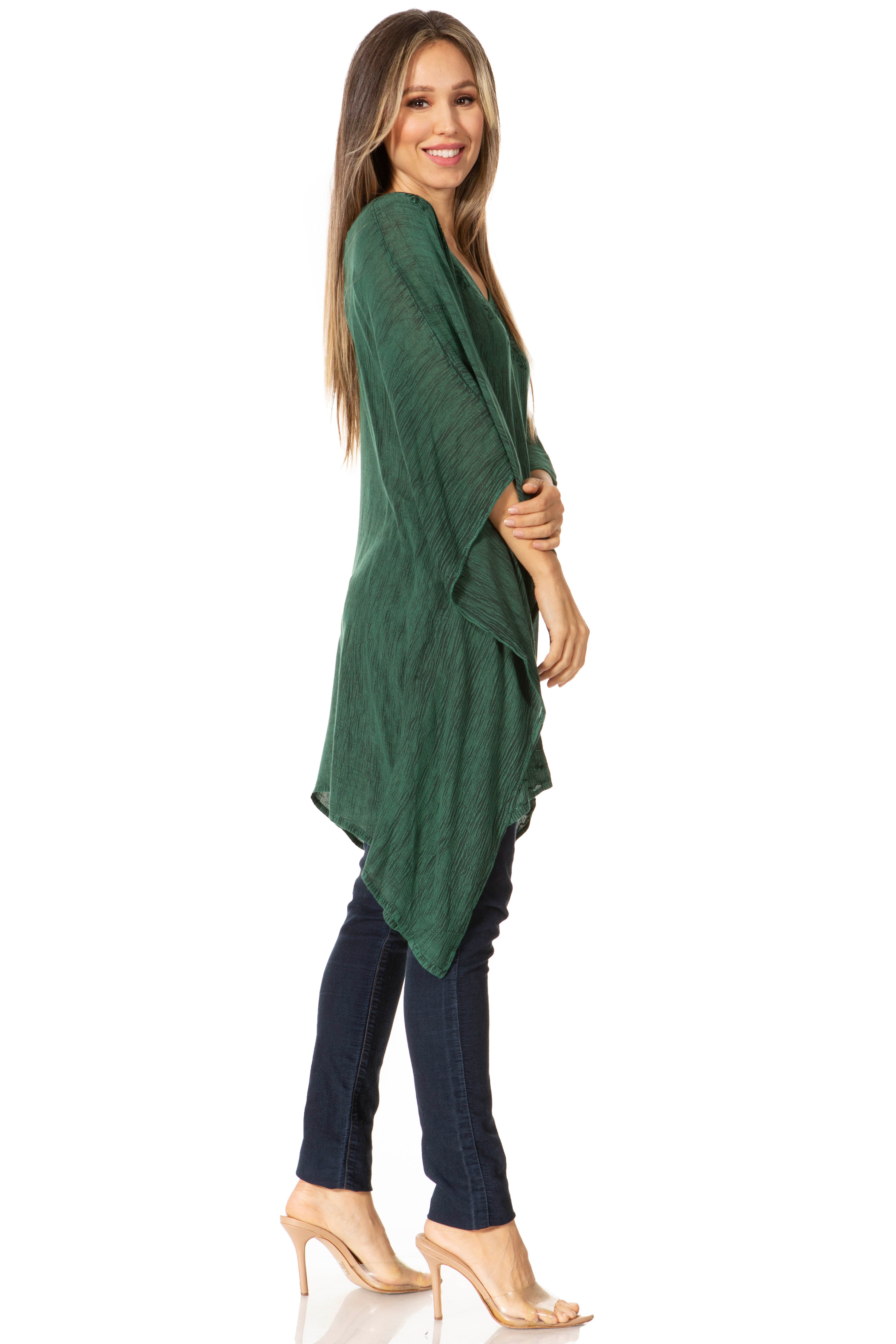 Woman wearing a green cardigan and dark jeans on a white background