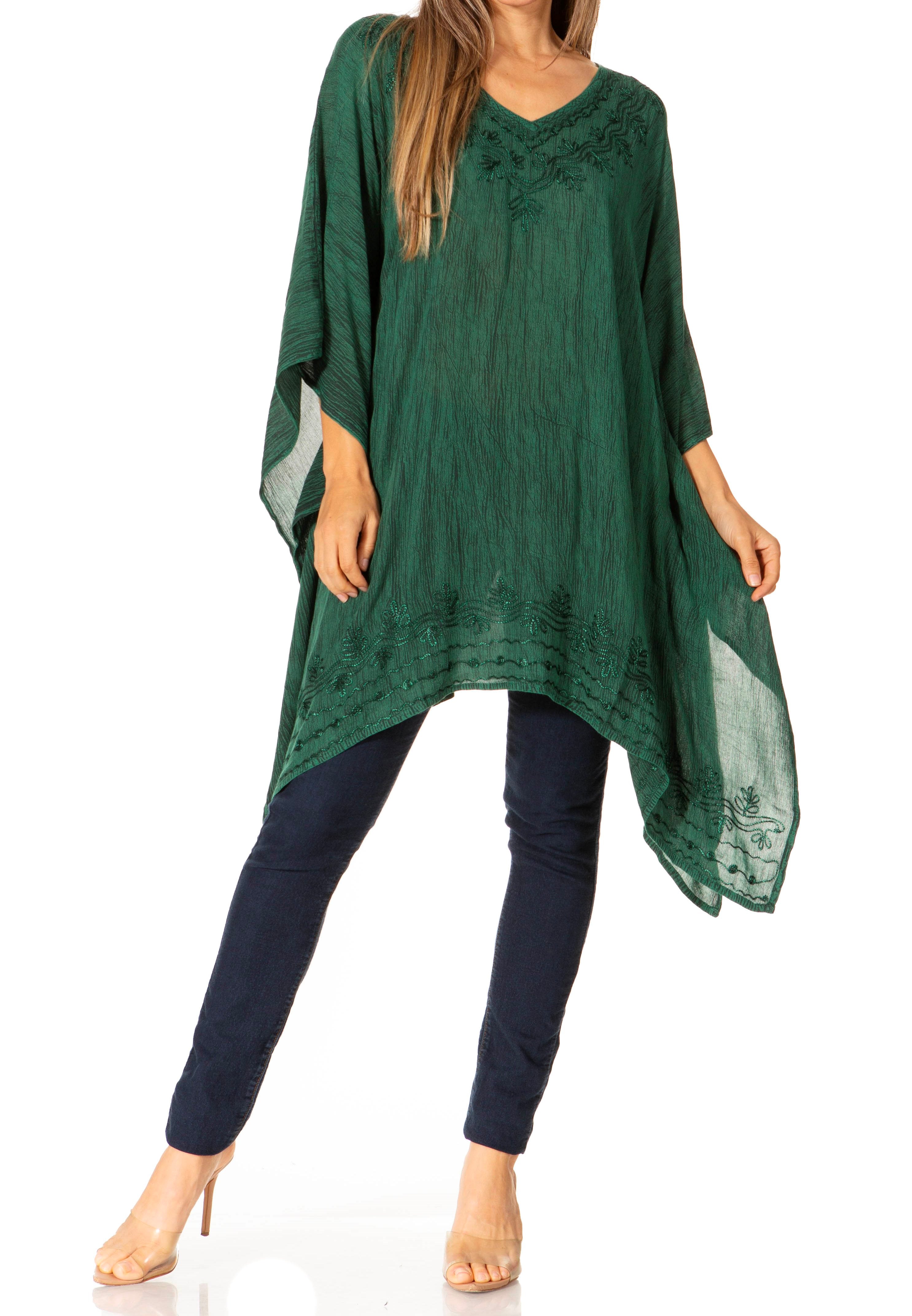 Green poncho over navy outfit on a white background
