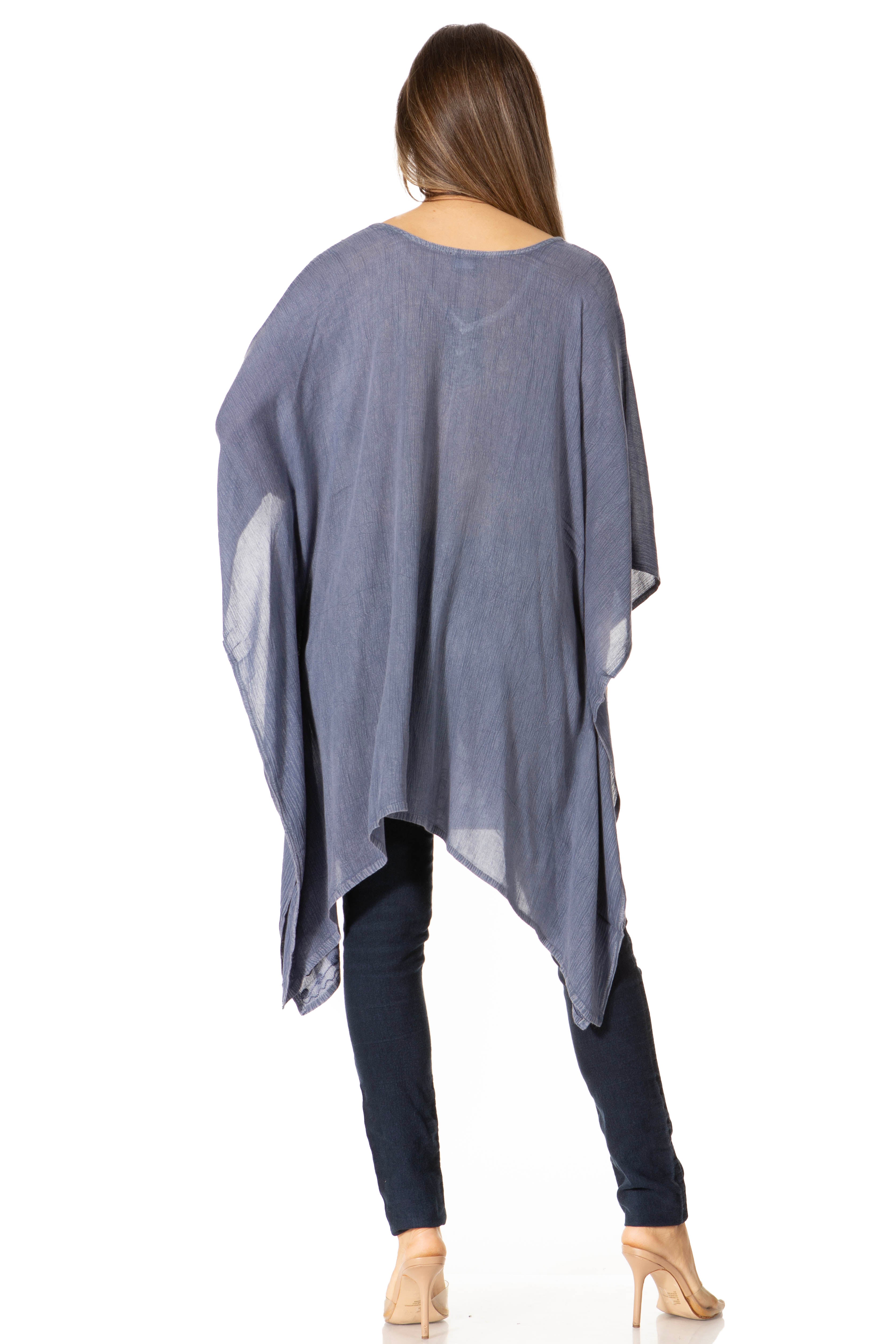Woman wearing a blue poncho over a black outfit on a white background