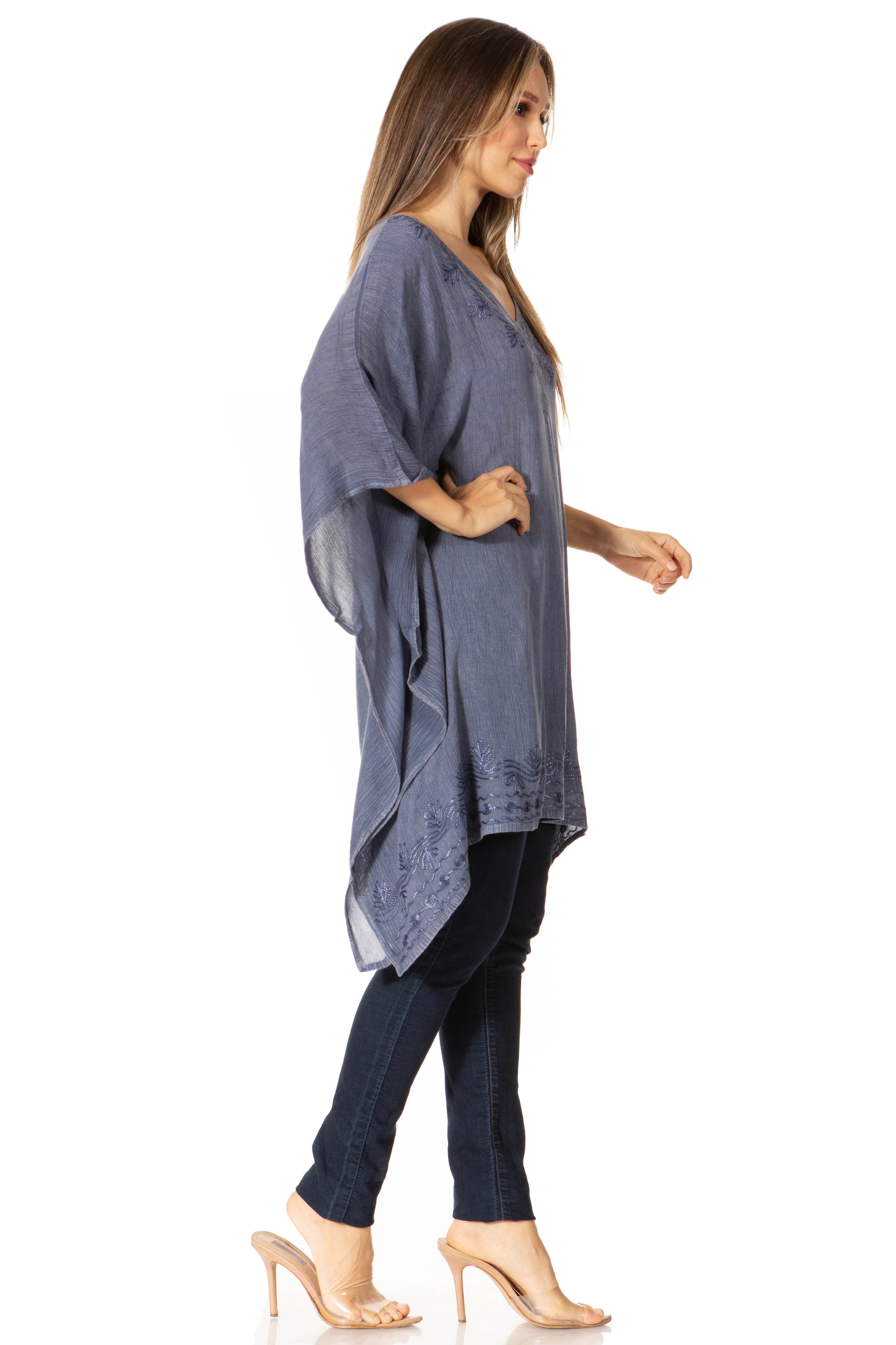 Woman wearing a blue kimono-style top and black pants on a white background