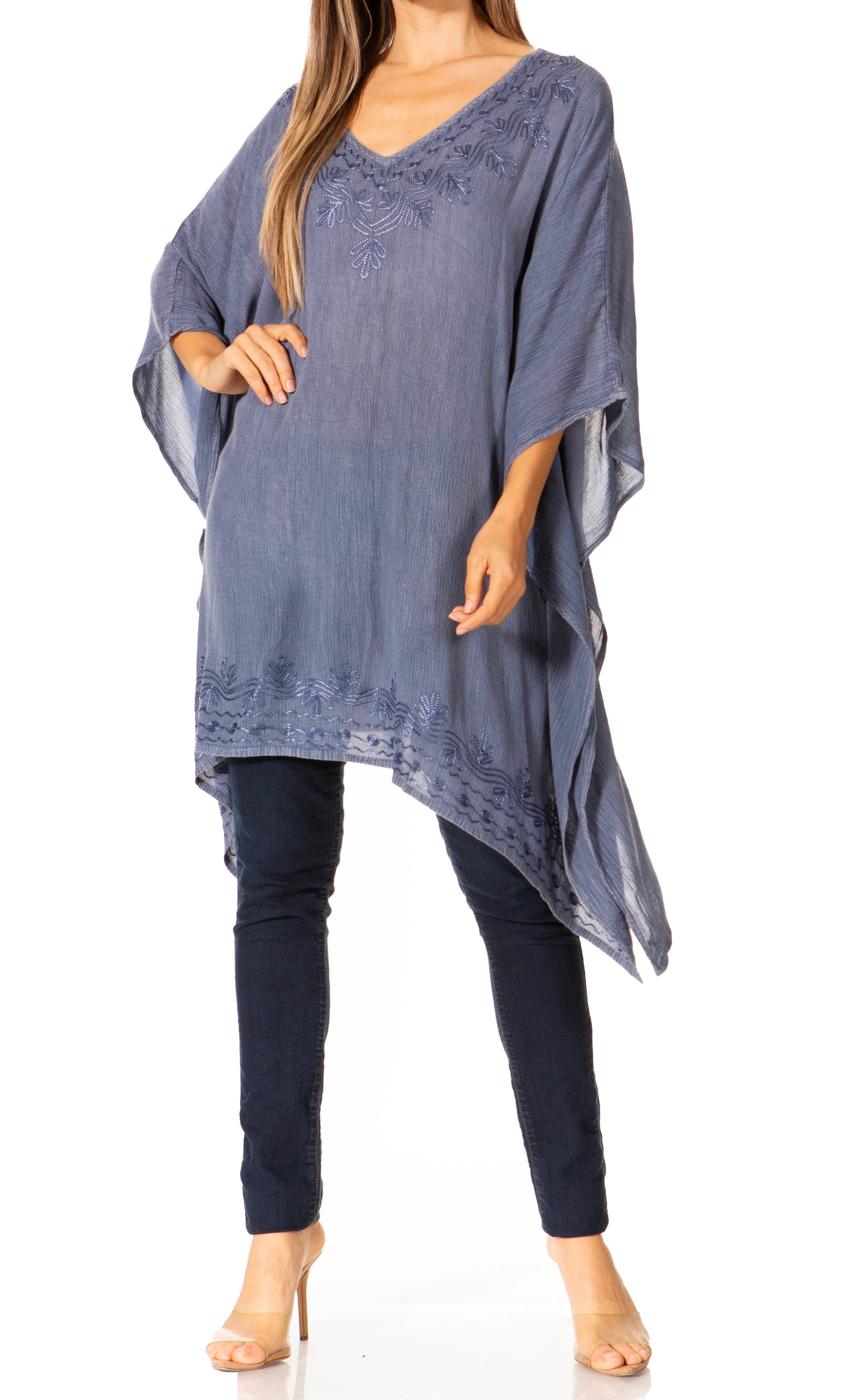 Woman wearing a blue poncho over a dark outfit on a white background