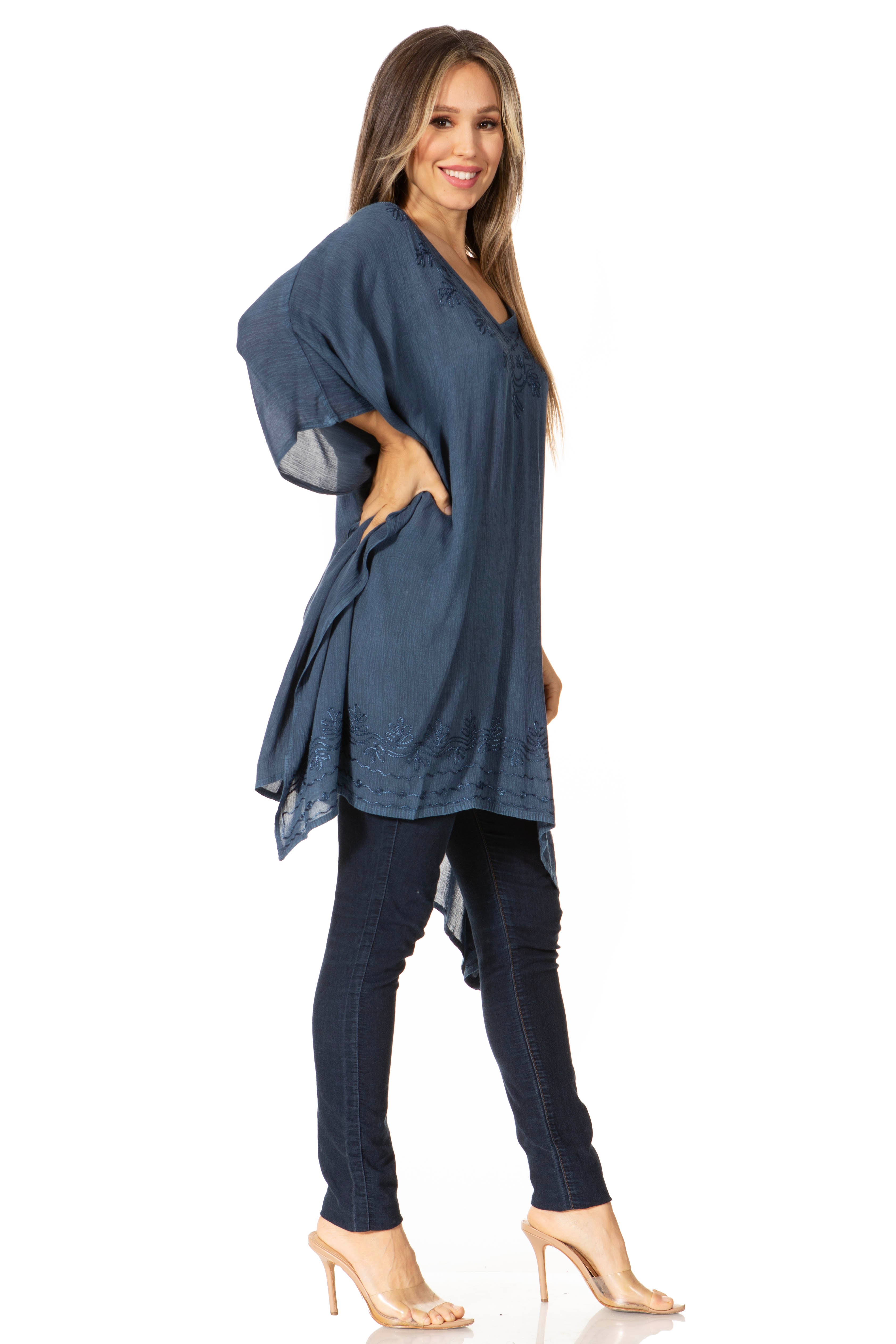 Woman wearing a blue tunic and dark pants on a white background