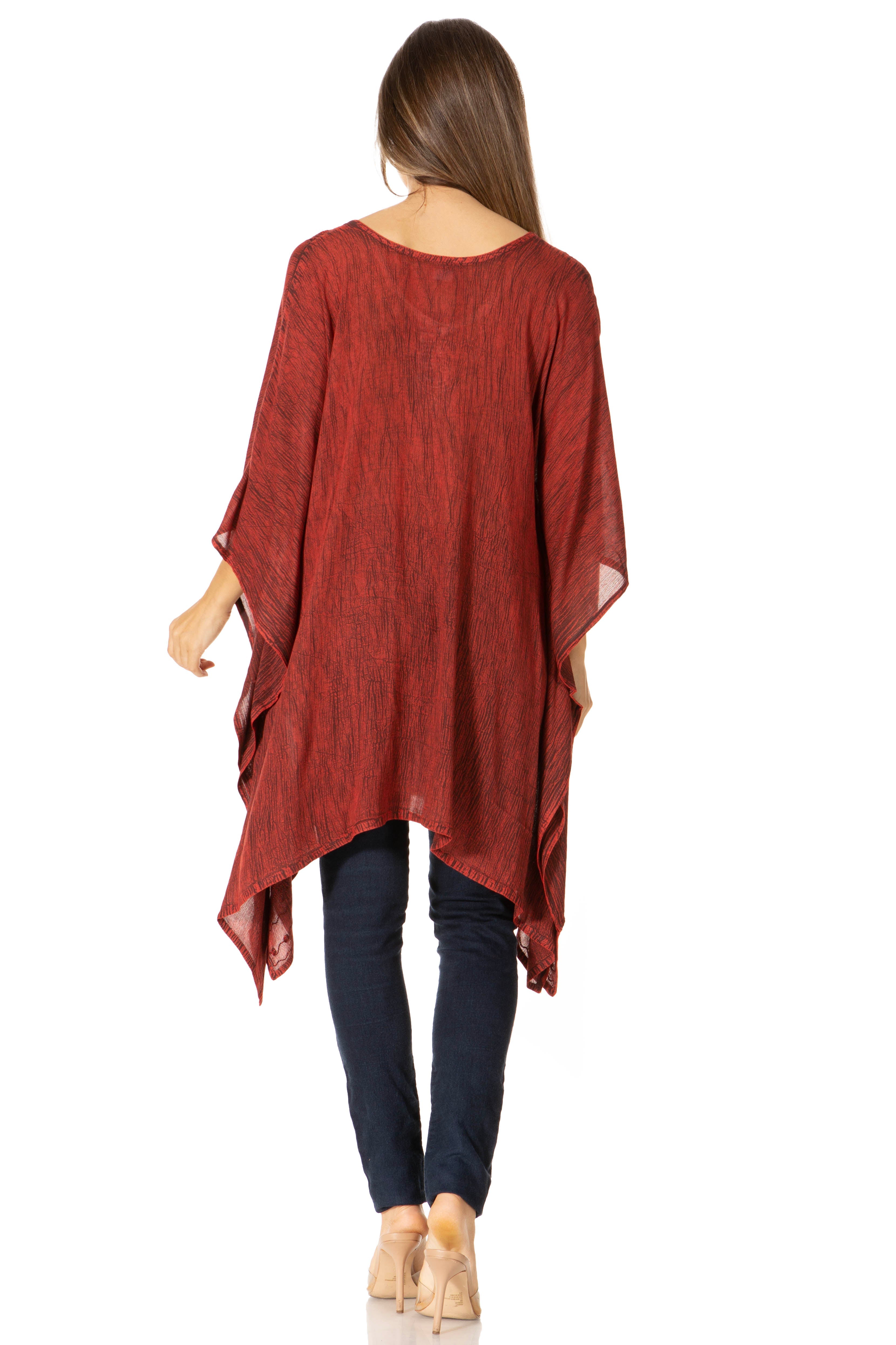 Woman wearing a red poncho over a dark outfit on a white background