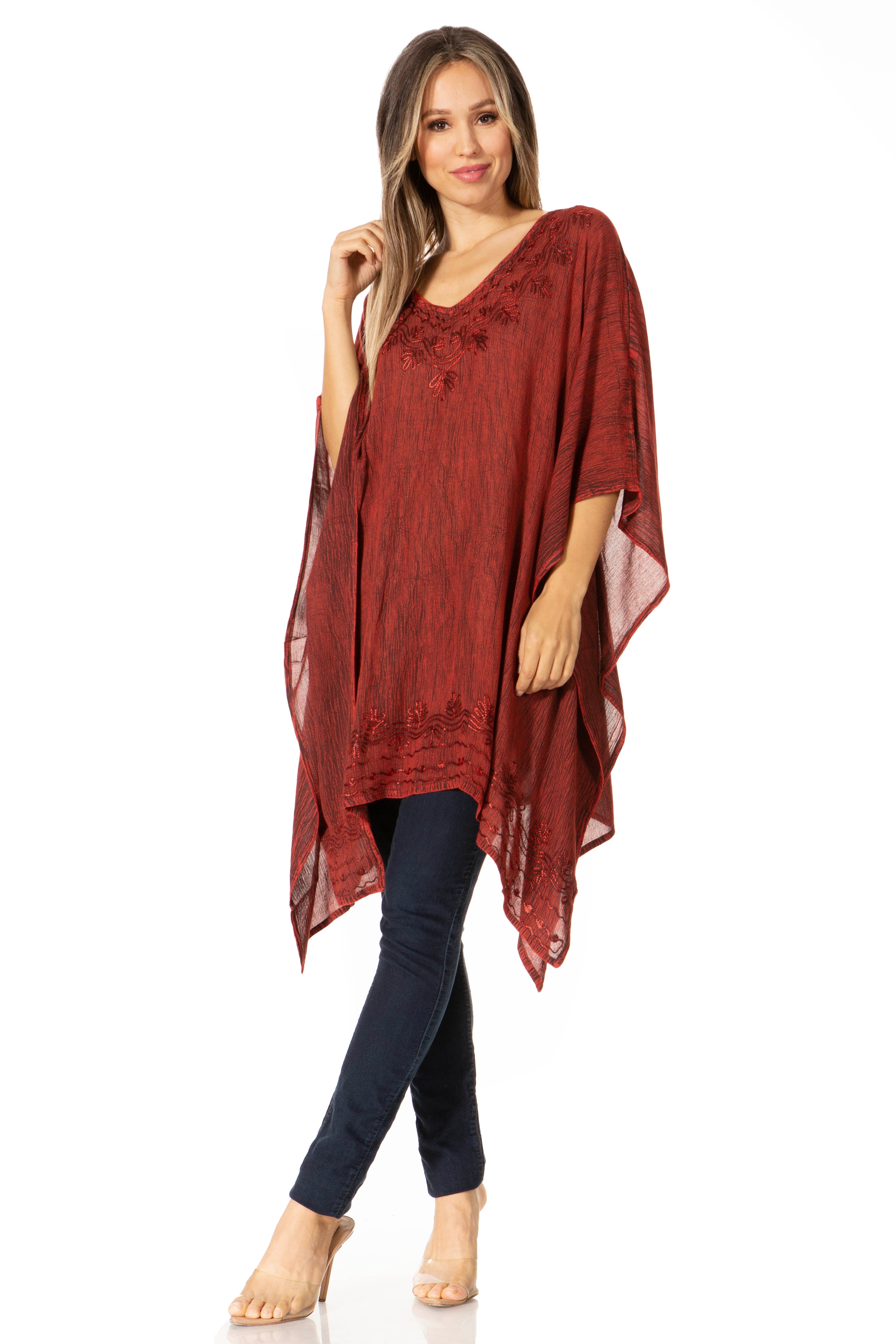 Woman wearing a red poncho over a dark top on a white background