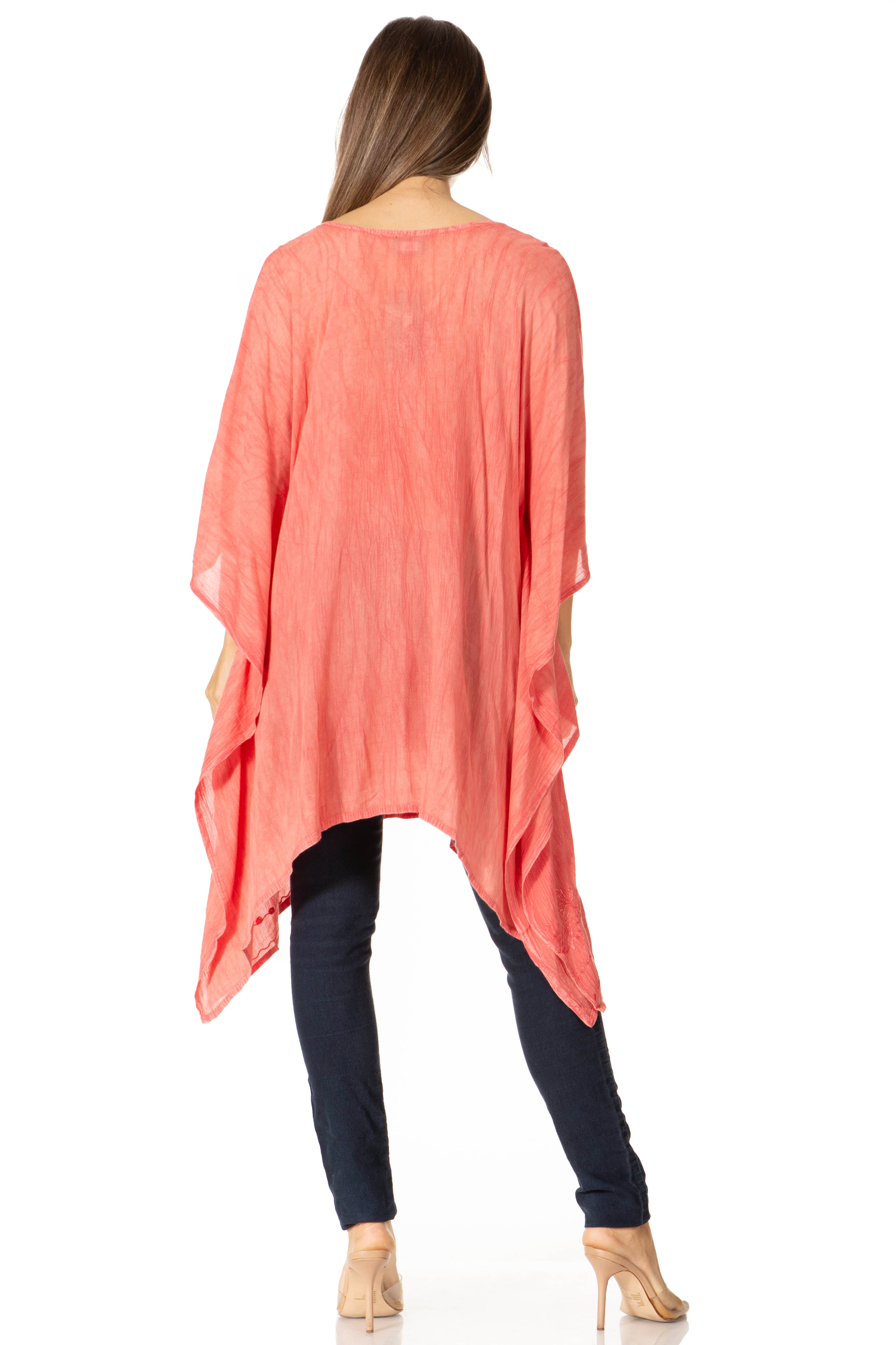 Woman wearing a coral oversized top and black pants on a white background