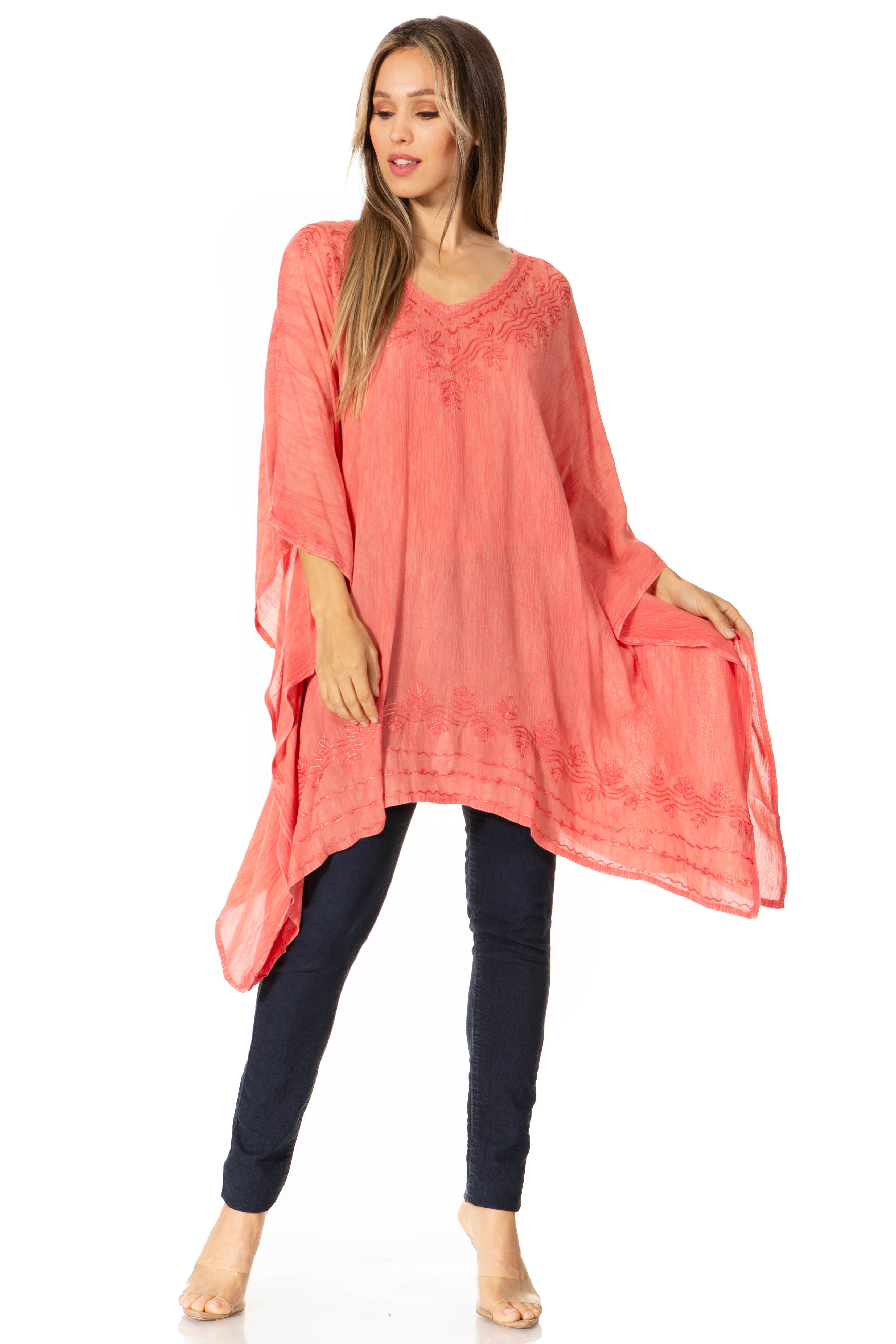 Woman wearing a coral tunic and dark pants on a white background