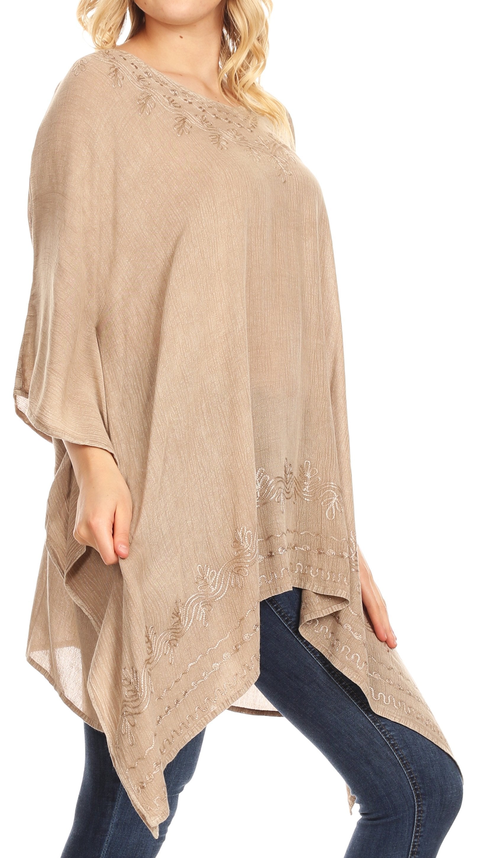 Beige poncho with lace details worn by a person on a white background