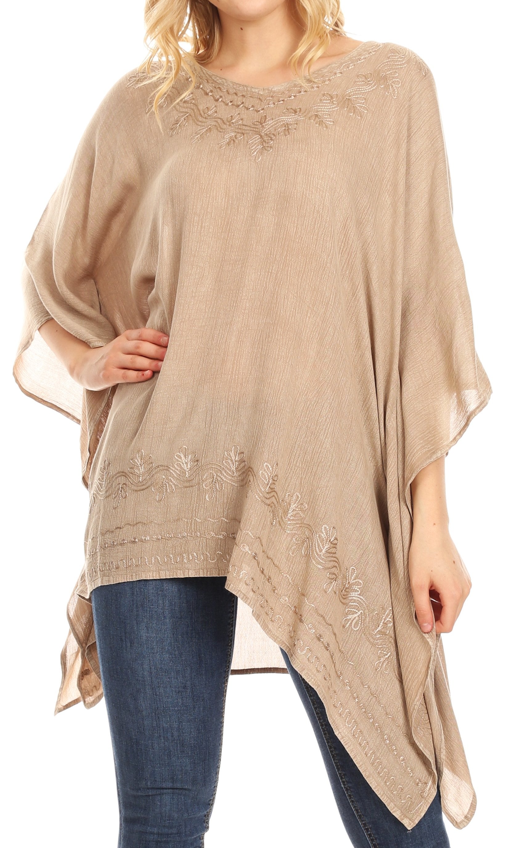 Beige poncho with floral embroidery worn by a person on a white background