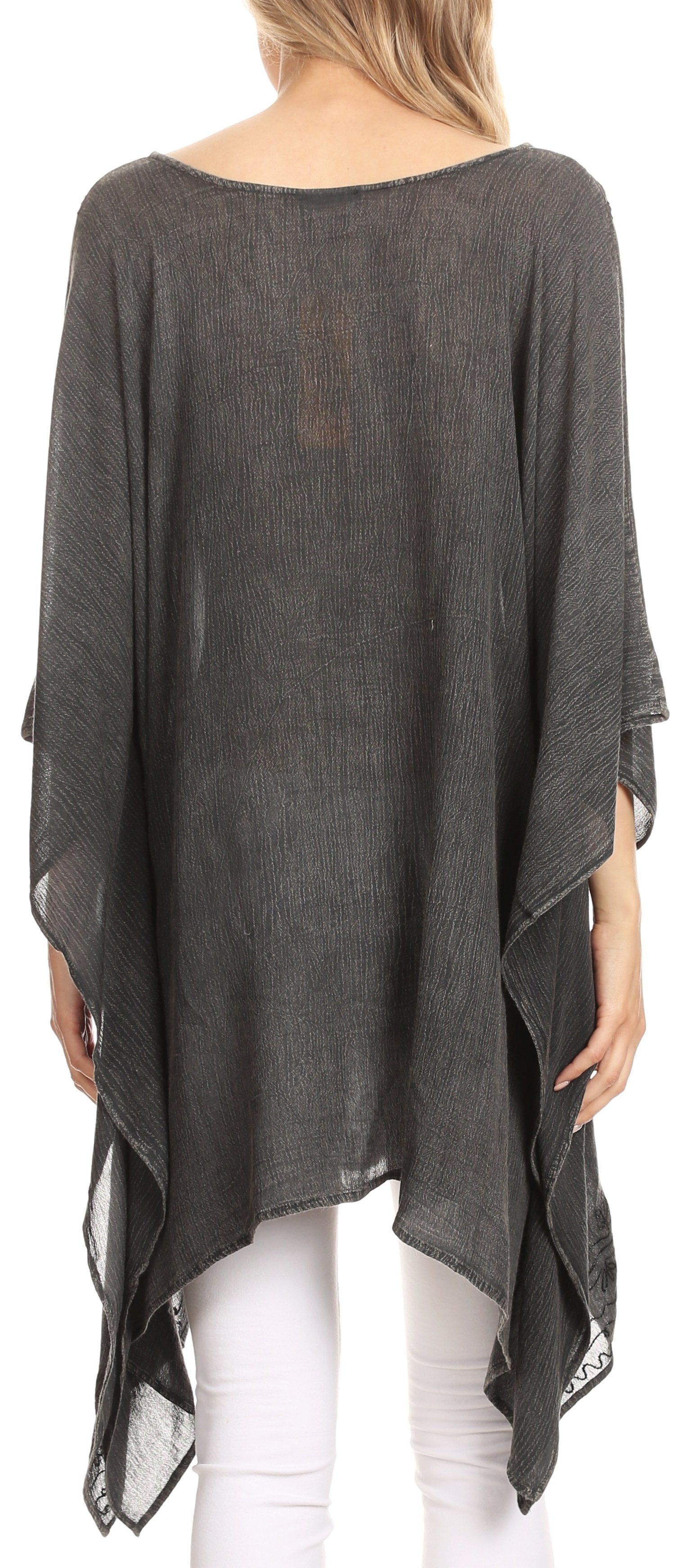 Dark gray poncho worn by a person with white pants