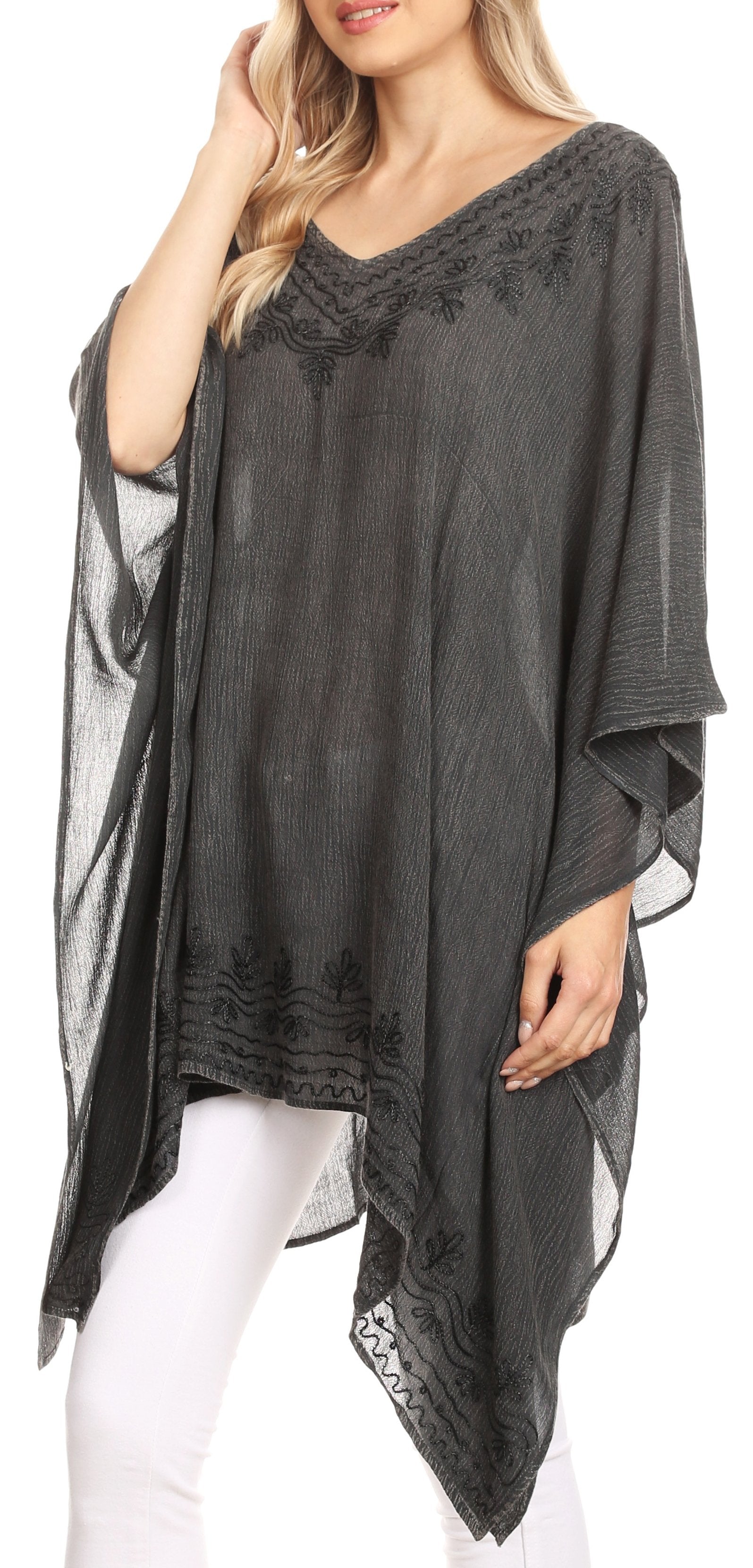 Woman wearing a dark gray poncho with lace details on a white background
