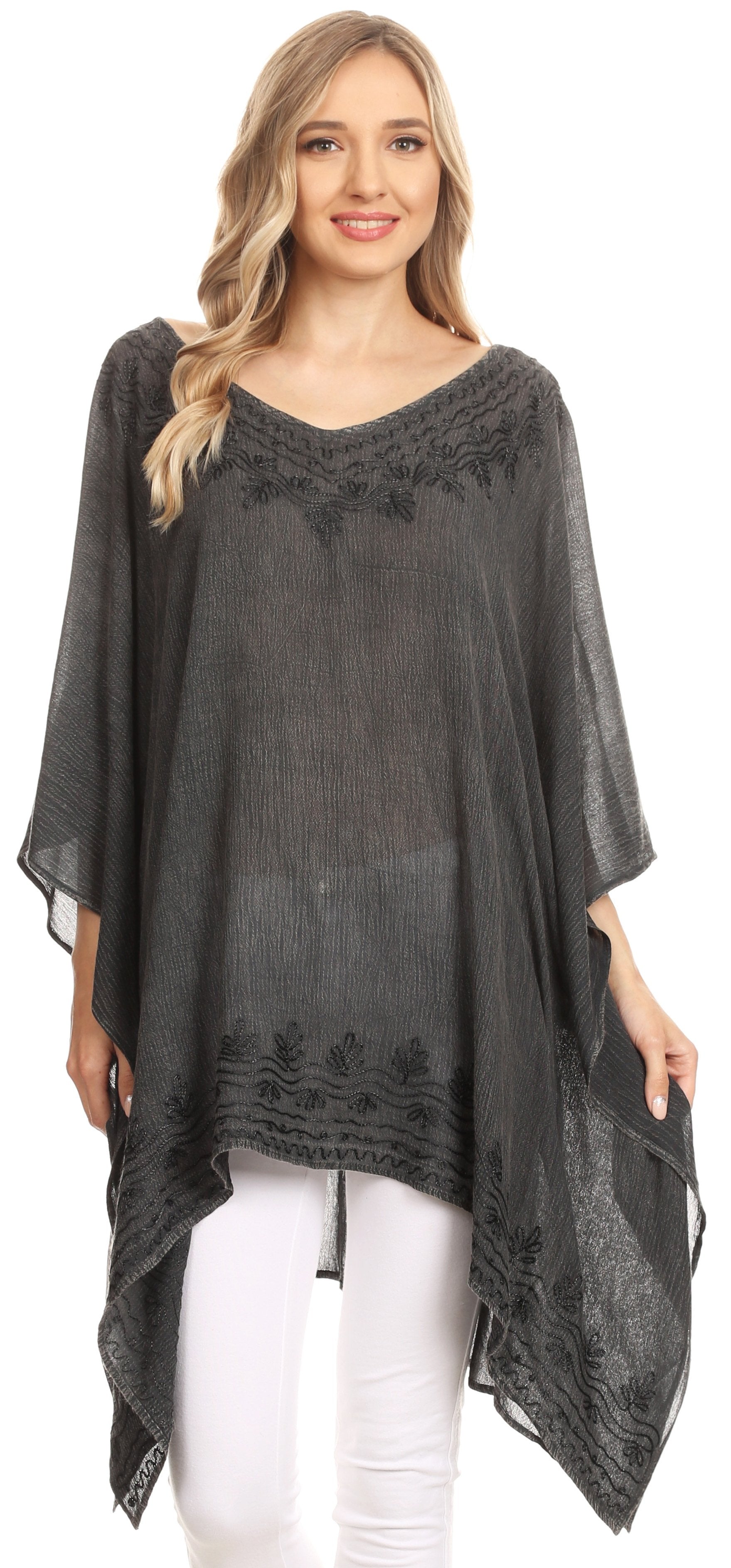 Woman wearing a dark gray poncho with lace details on a white background