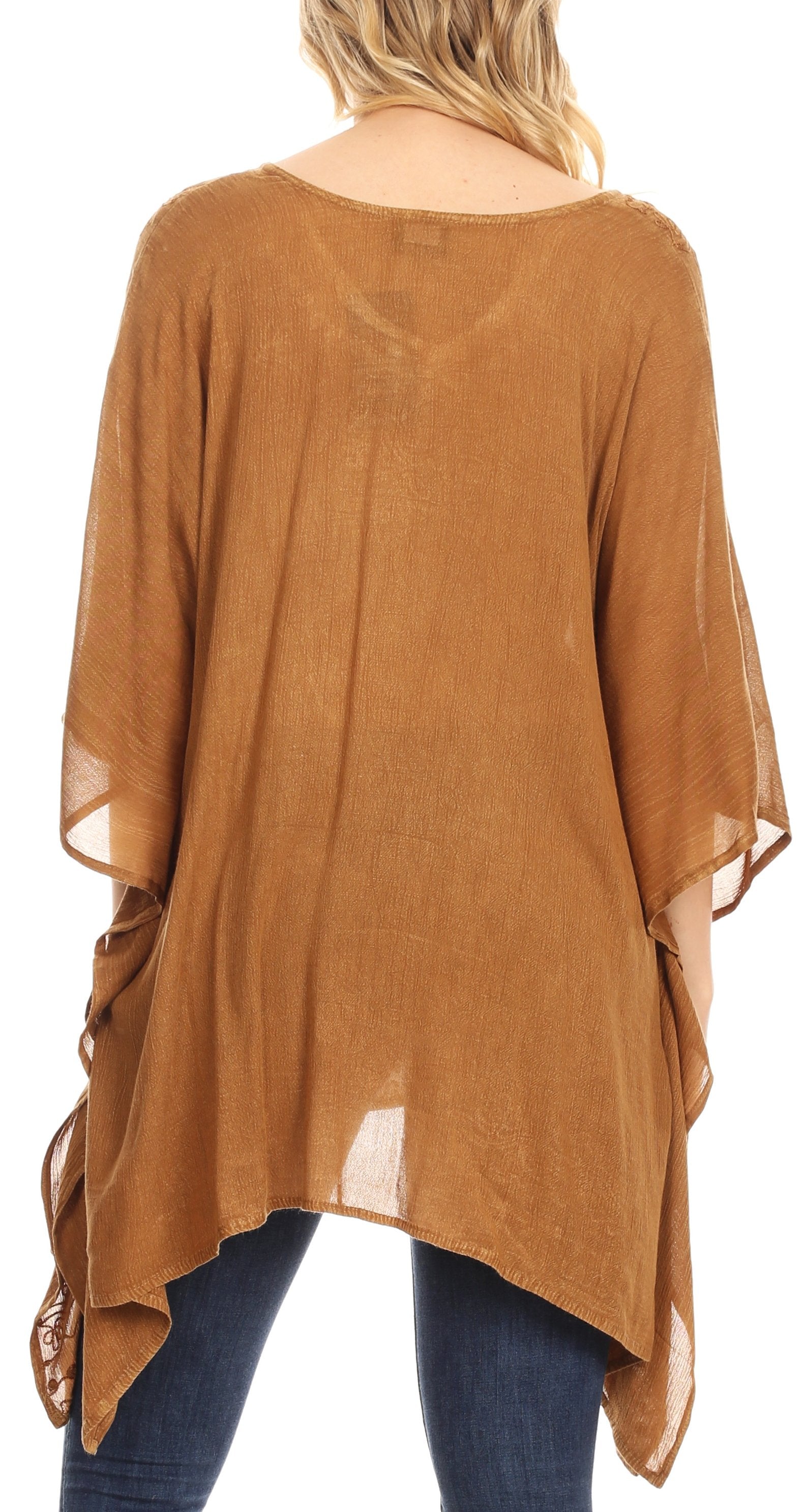 Brown poncho with sheer sleeves over blue jeans on a white background