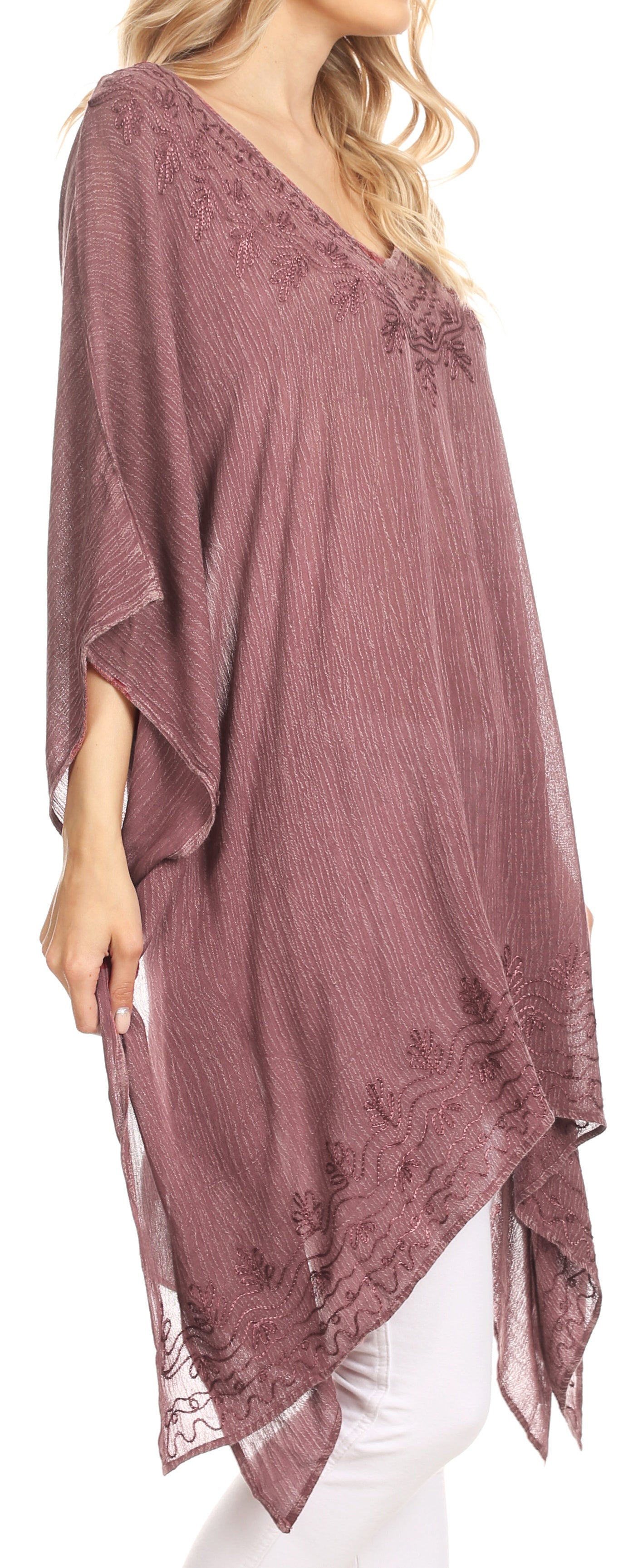 Mauve poncho with lace details worn by a model on a white background