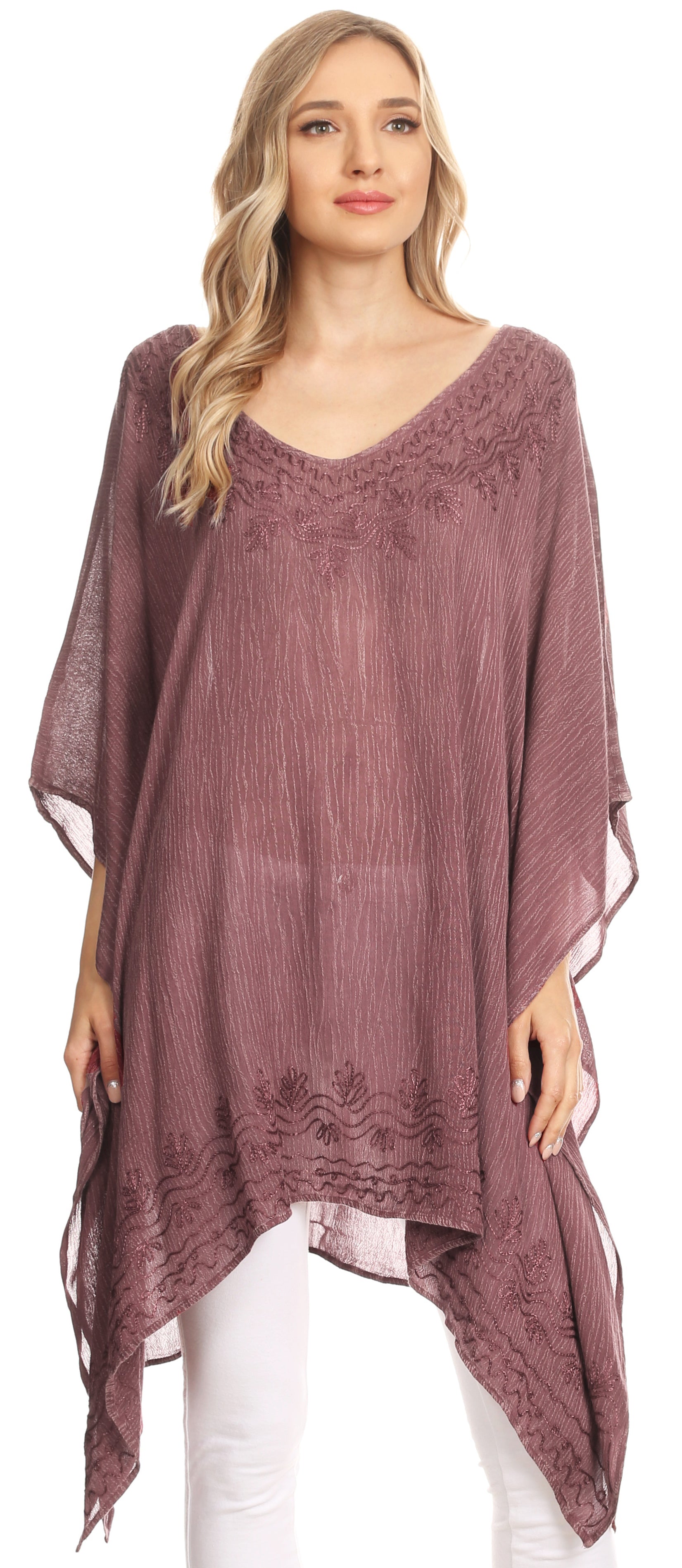 Woman wearing a mauve poncho with lace details on a white background