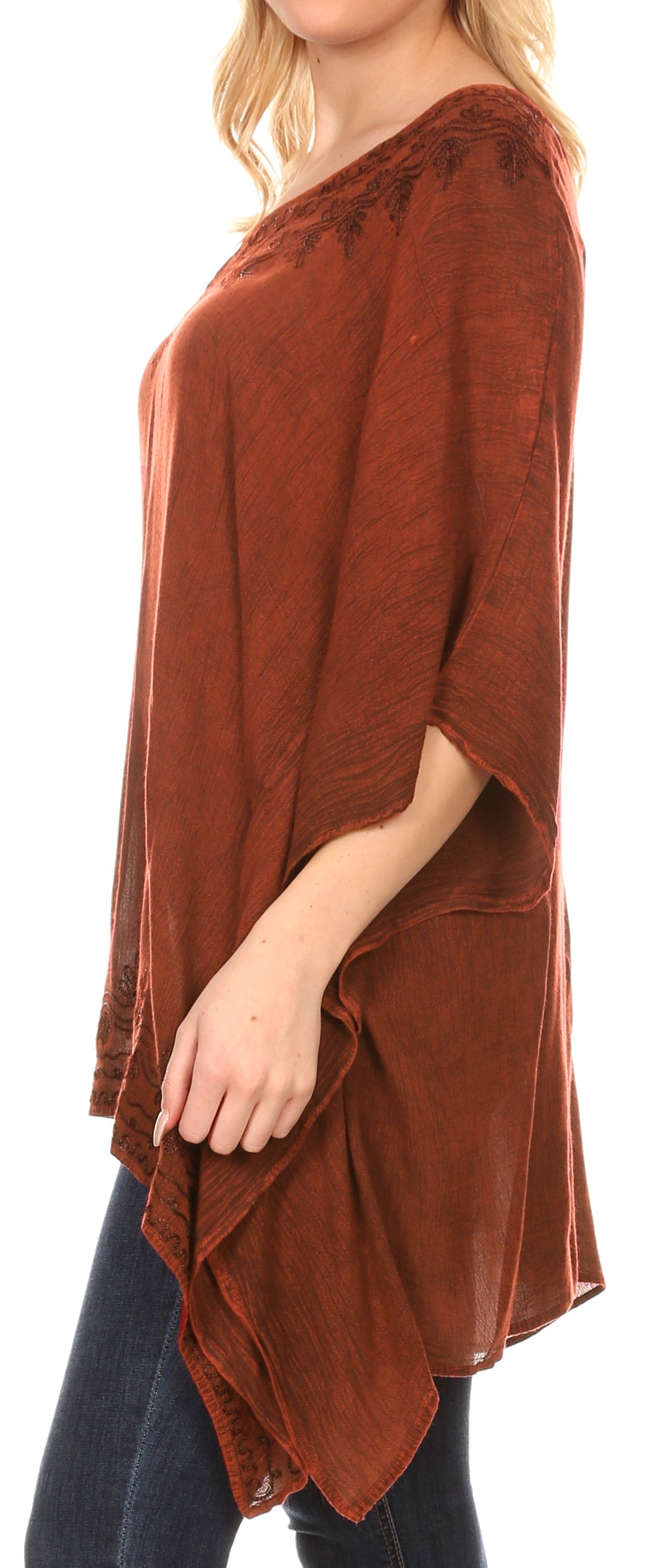 Brown poncho with lace details worn by a person on a white background