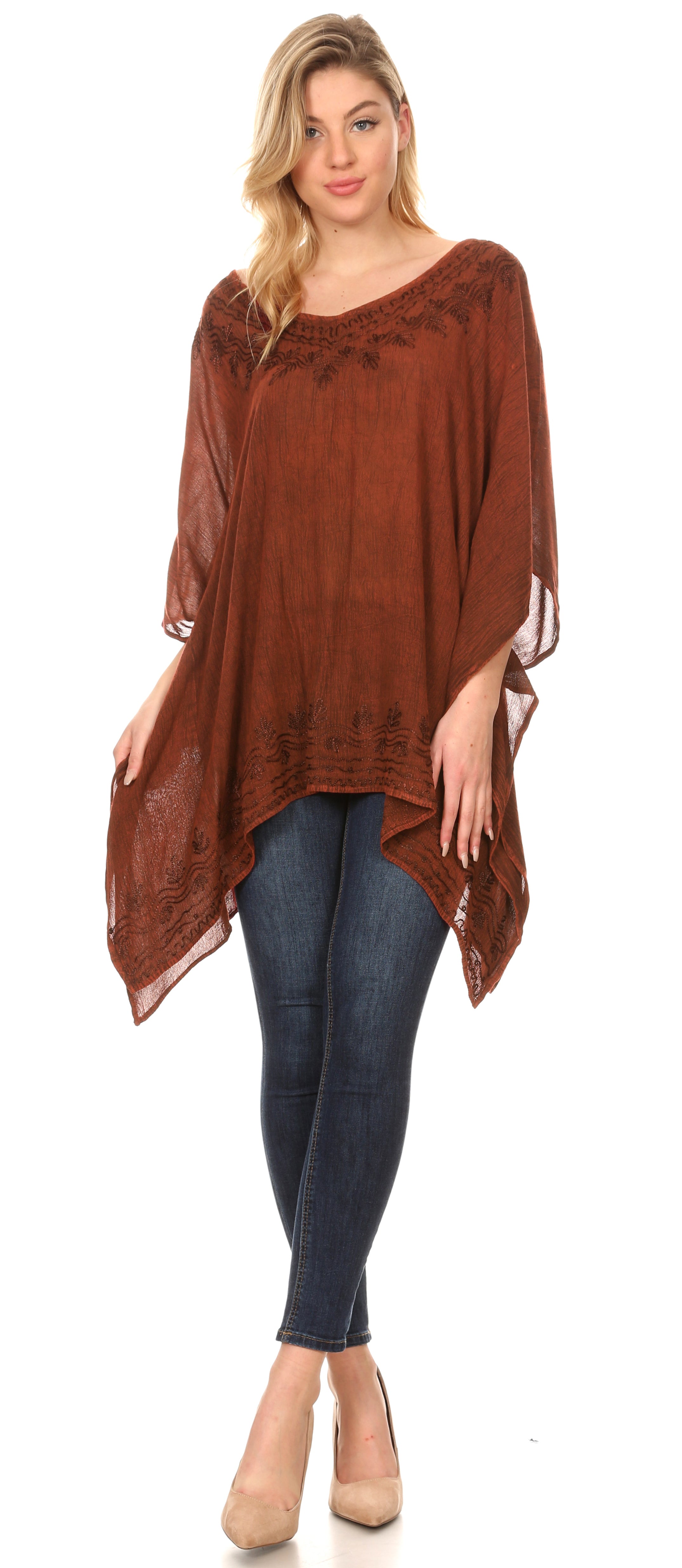 Woman wearing a brown poncho over a blue outfit on a white background