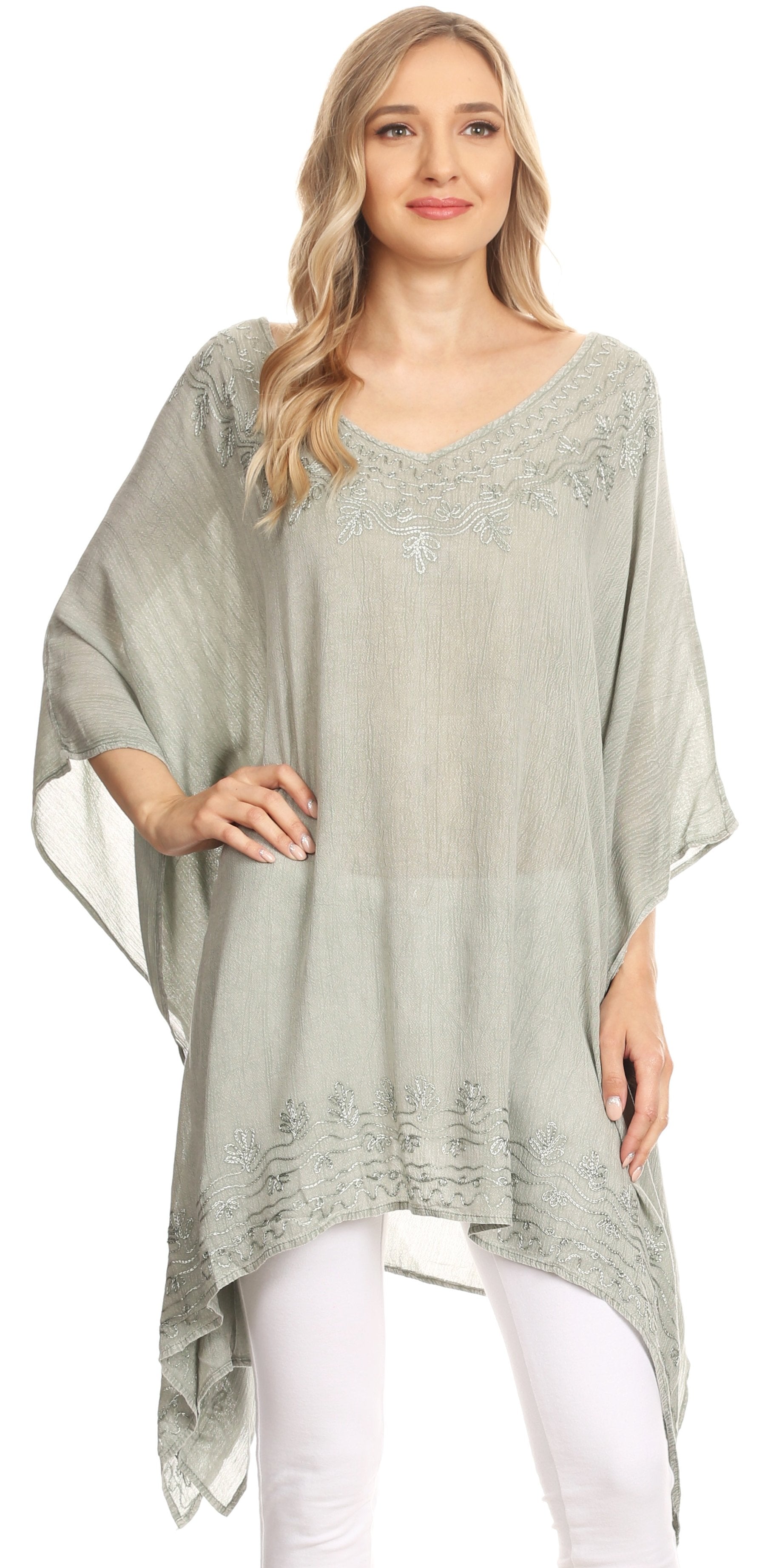 Woman wearing a light green poncho with a subtle pattern on a white background
