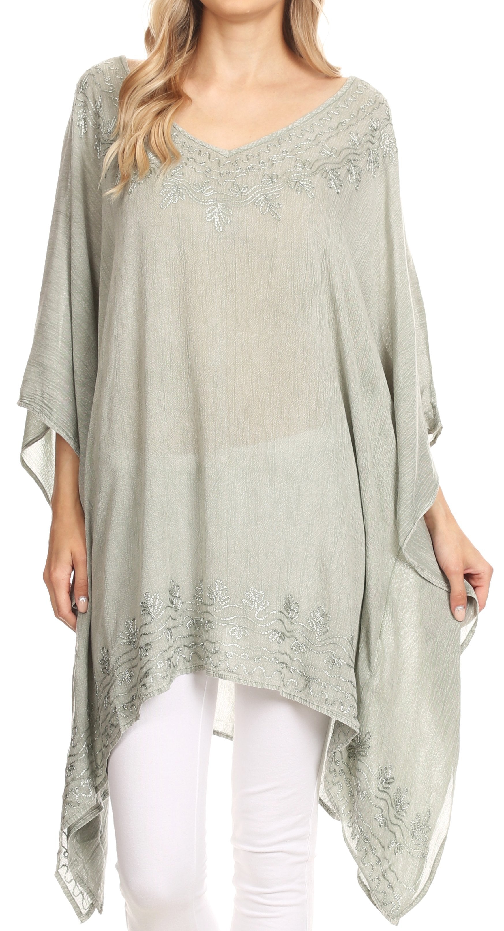 Woman wearing a light green poncho with lace details on a white background