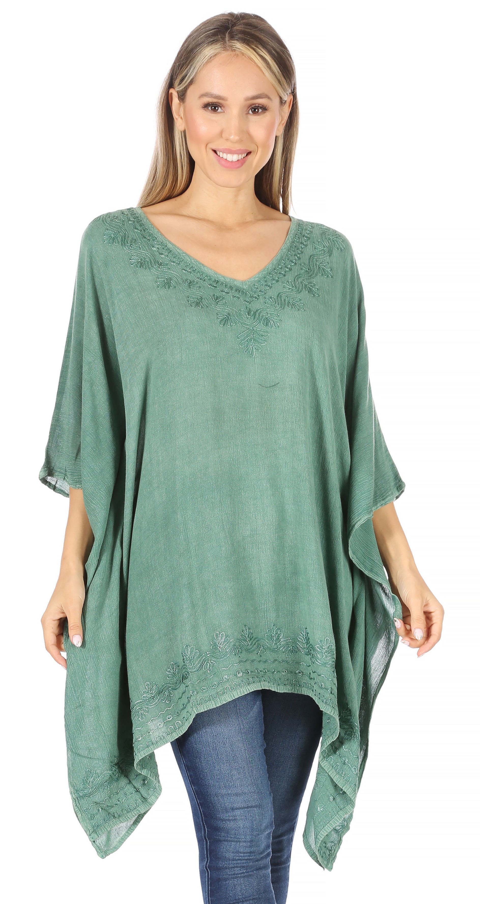 Woman wearing a green poncho with lace details on a white background