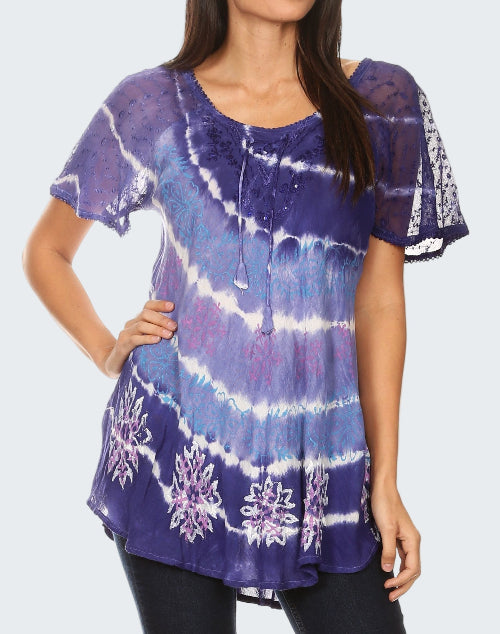 Woman wearing a purple tie-dye shirt with floral patterns on a white background
