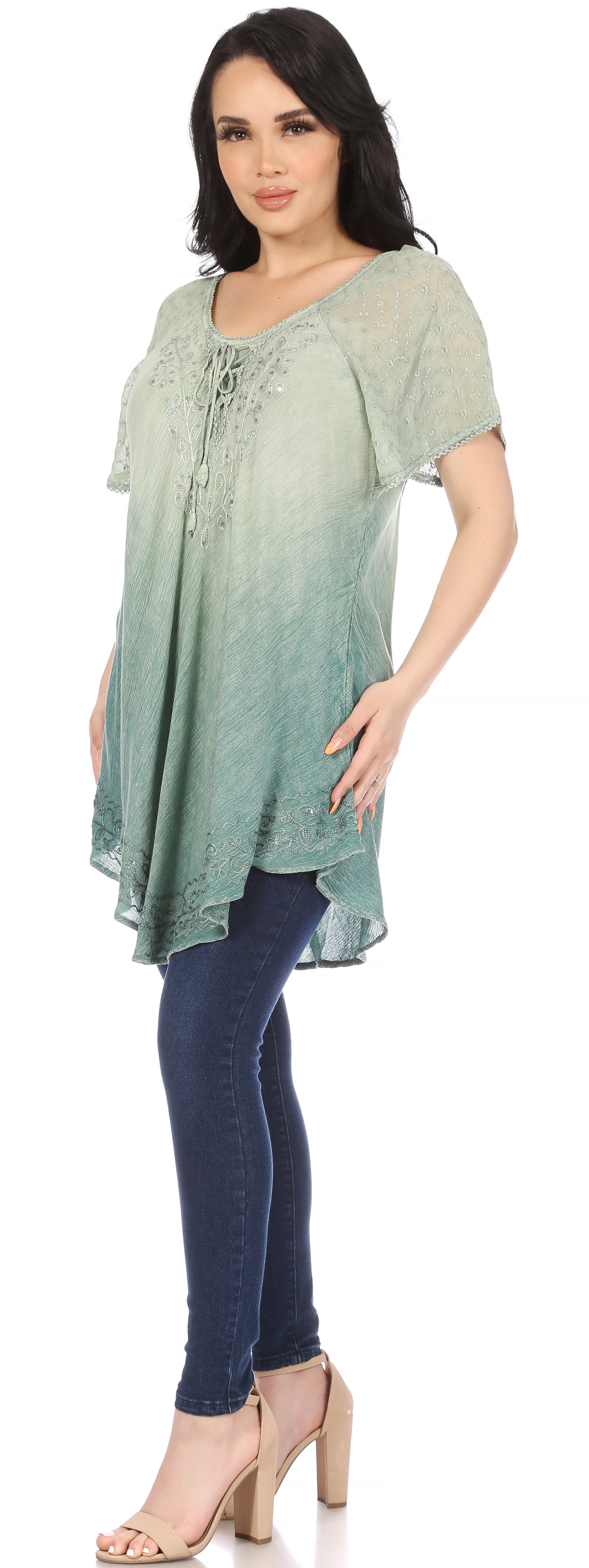 Woman wearing a green ombre top and blue jeans on a white background