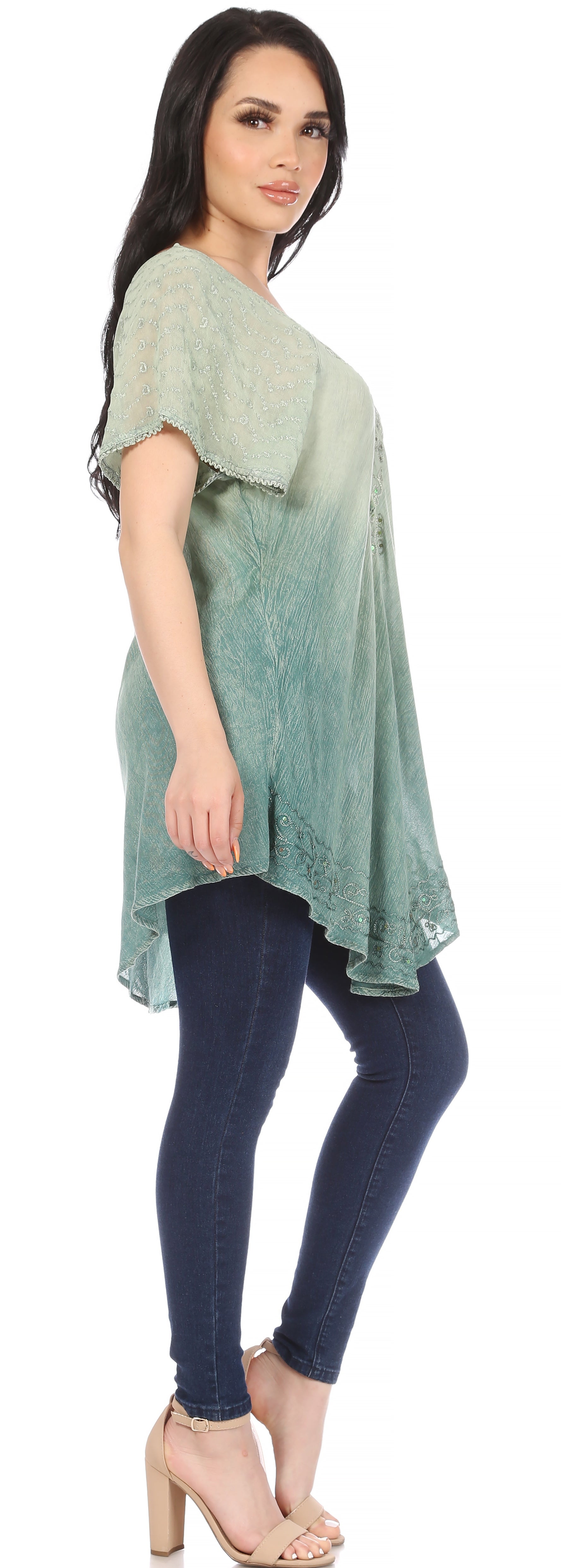 Woman wearing a green gradient top and dark blue jeans on a white background