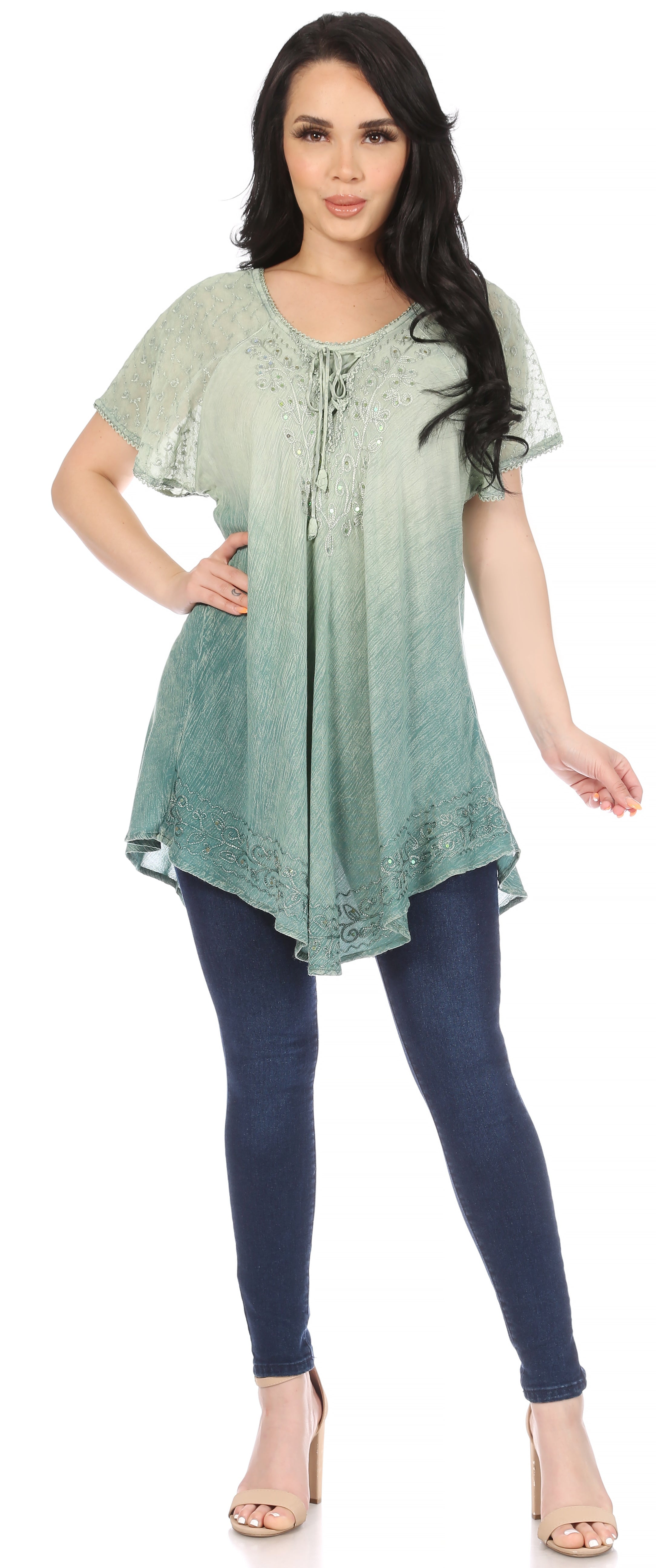 Woman wearing a green gradient top and blue leggings on a white background