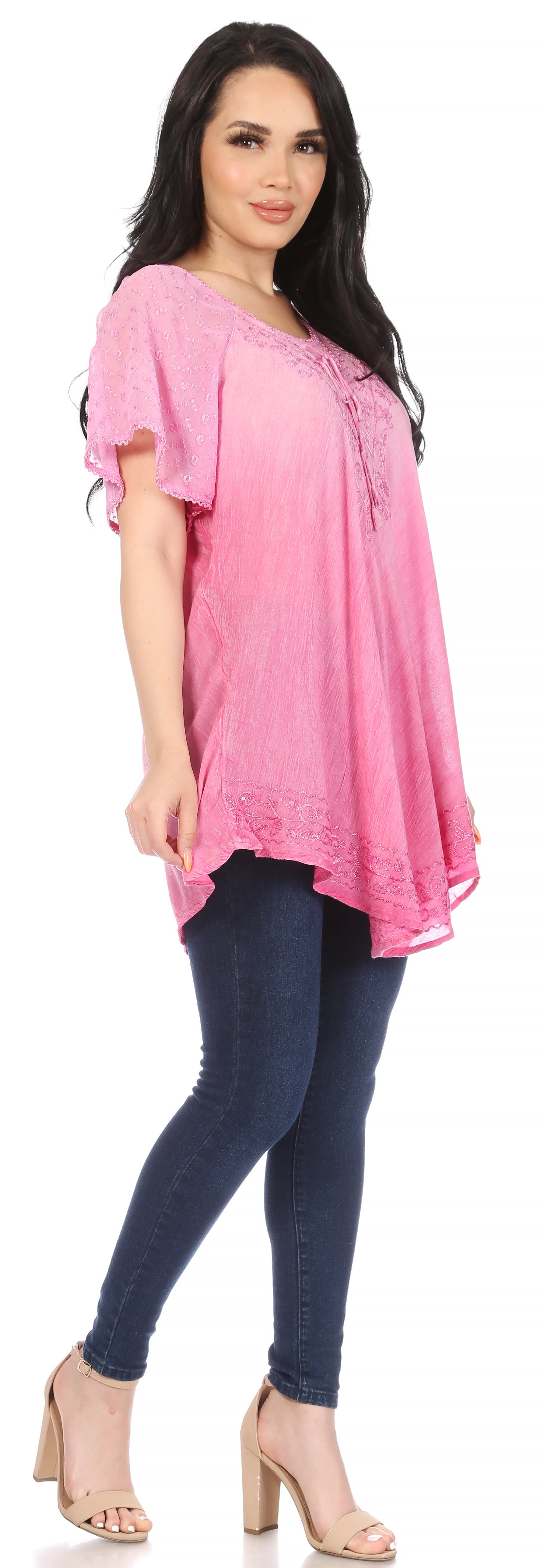 Woman wearing a pink top and blue jeans on a white background