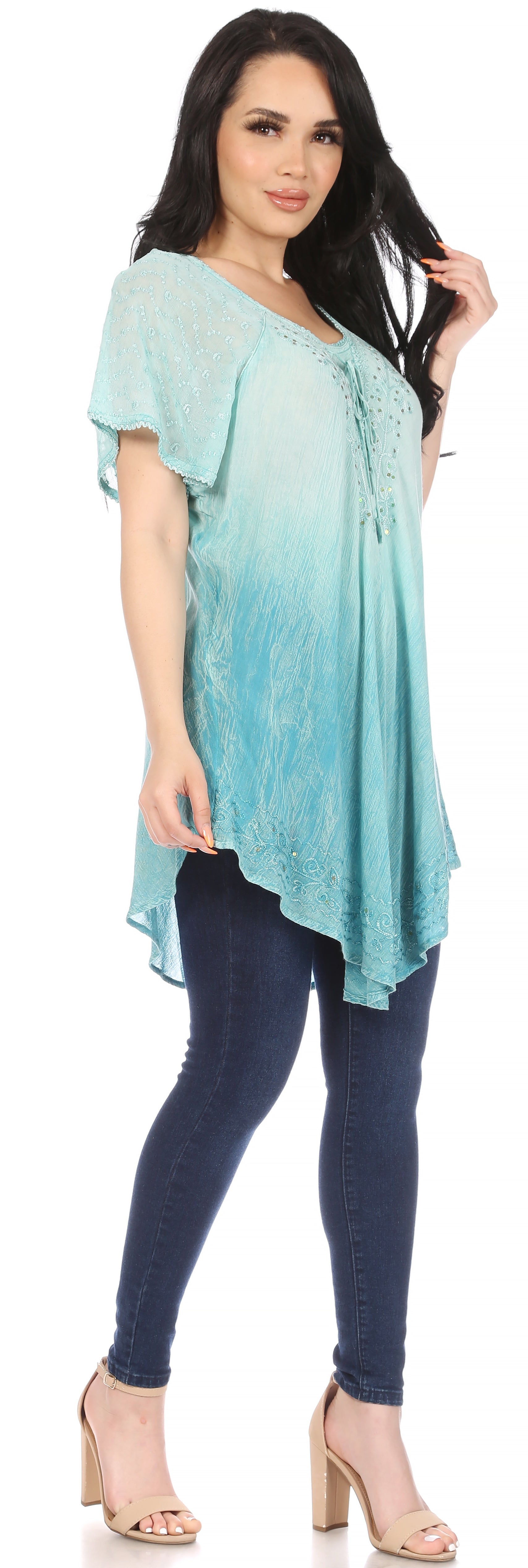 Woman wearing a teal and blue ombre tunic and dark blue leggings on a white background