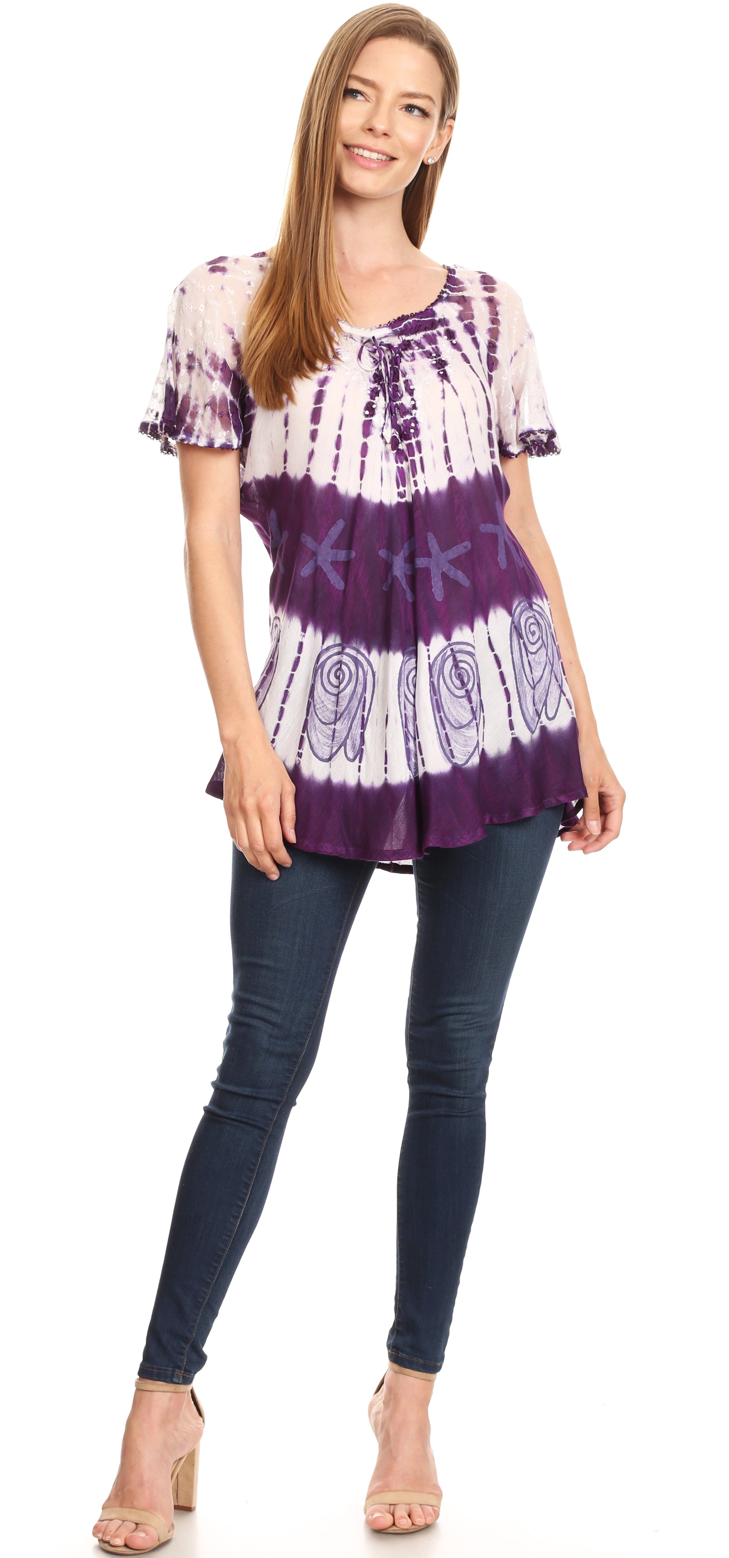 Woman wearing a tie-dye shirt and jeans on a white background