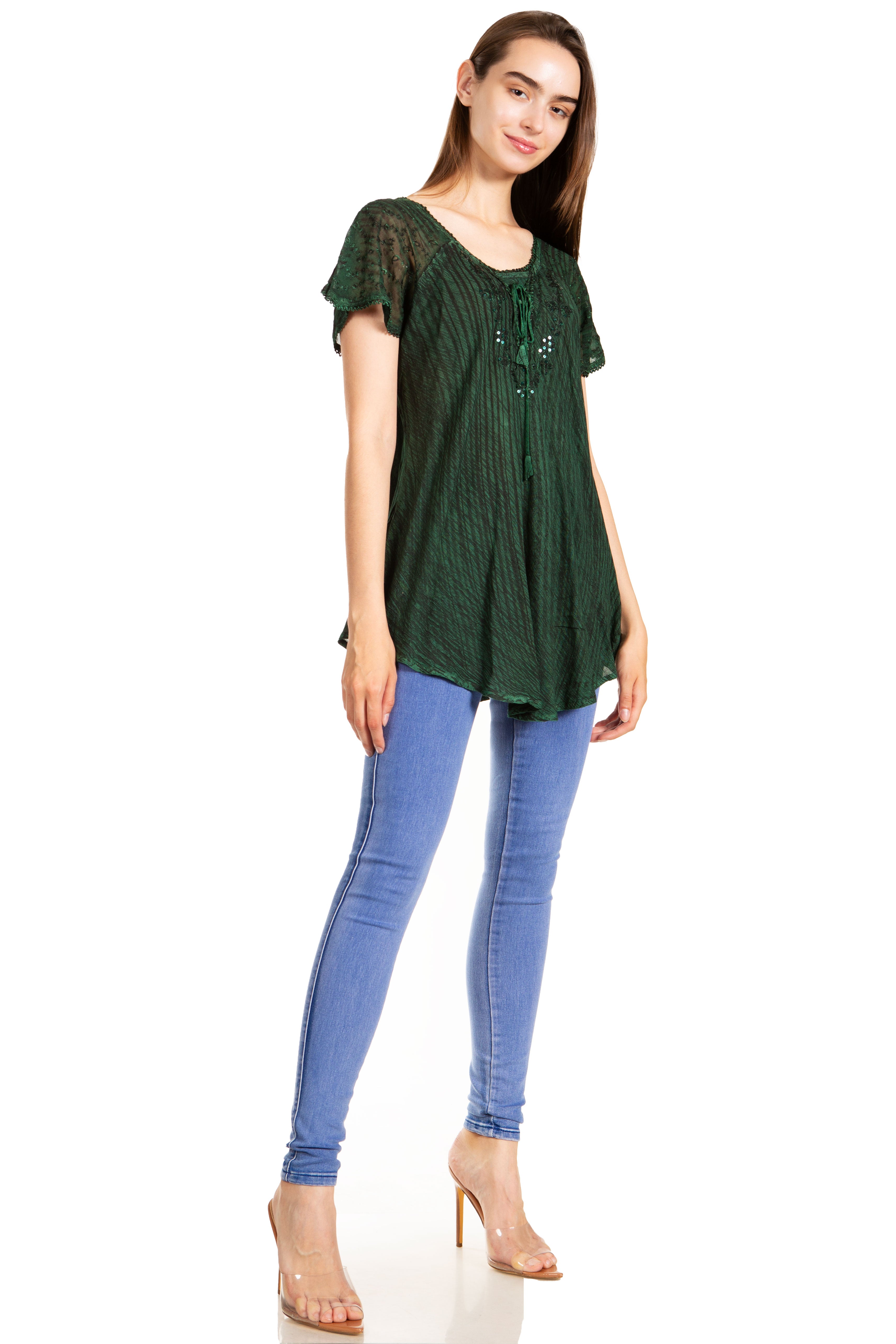 Woman wearing a green top and blue jeans on a white background