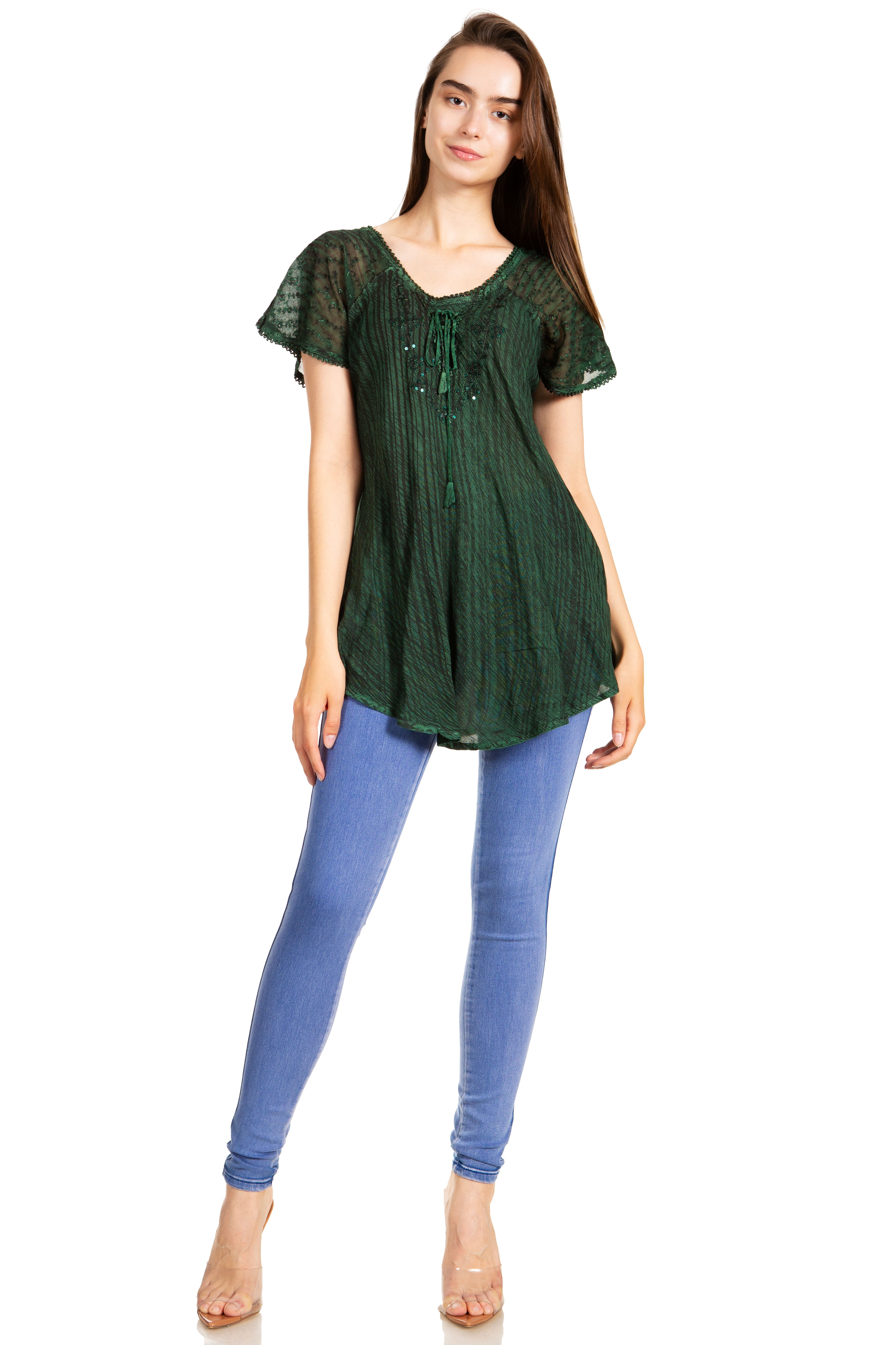 Woman wearing a green lace top and blue jeans on a white background