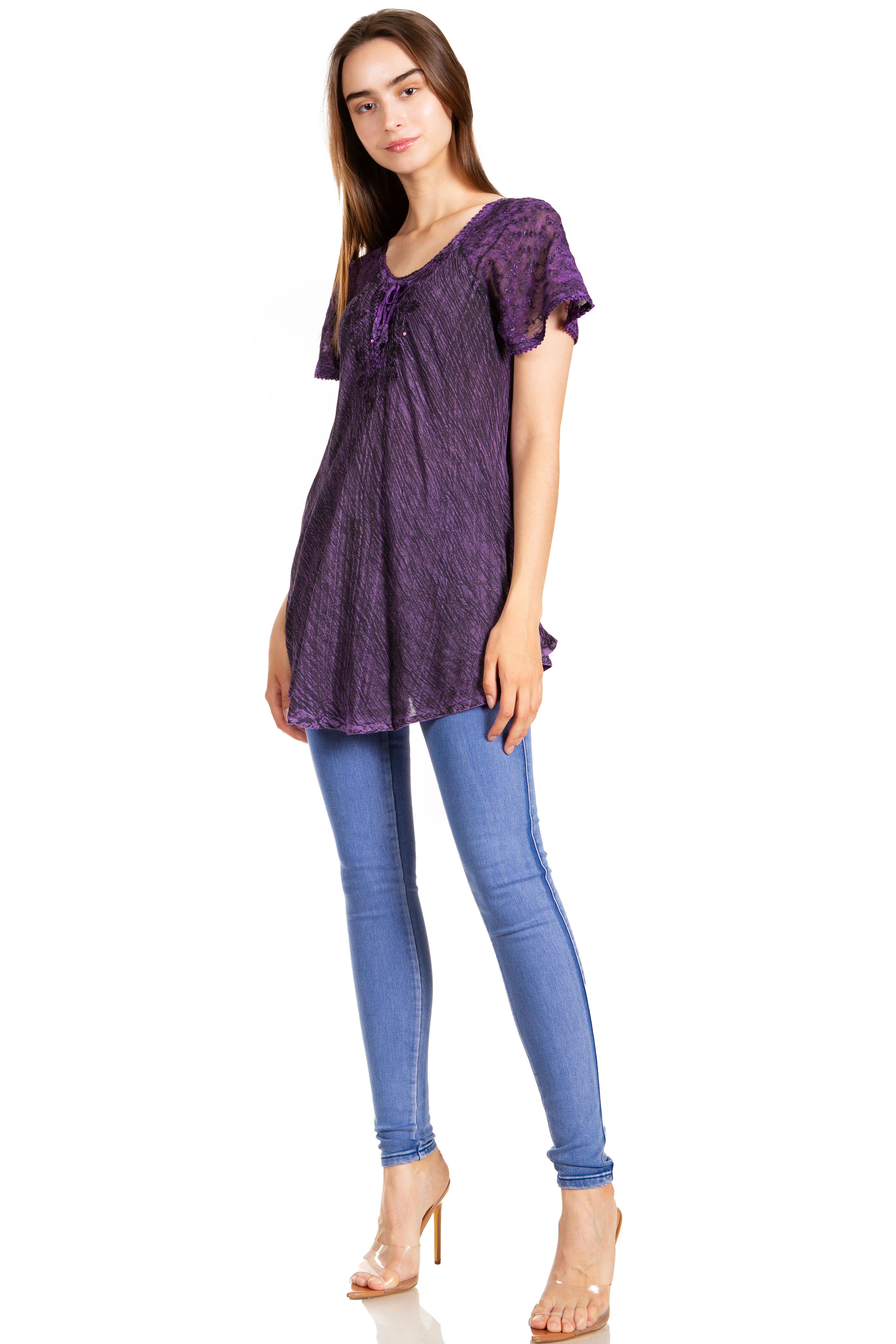 Woman wearing a purple top and blue jeans on a white background