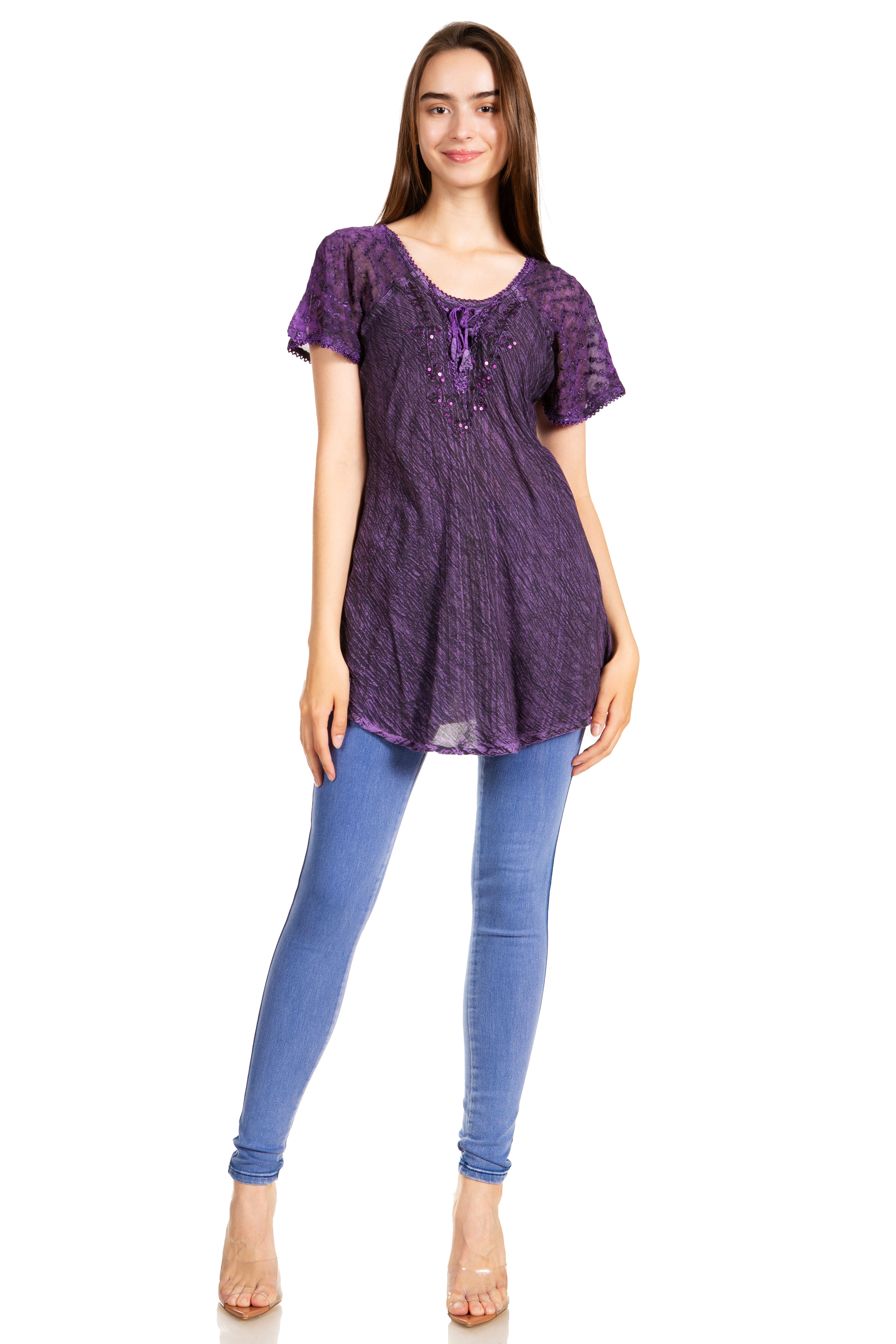 Woman wearing a purple top and blue jeans on a white background