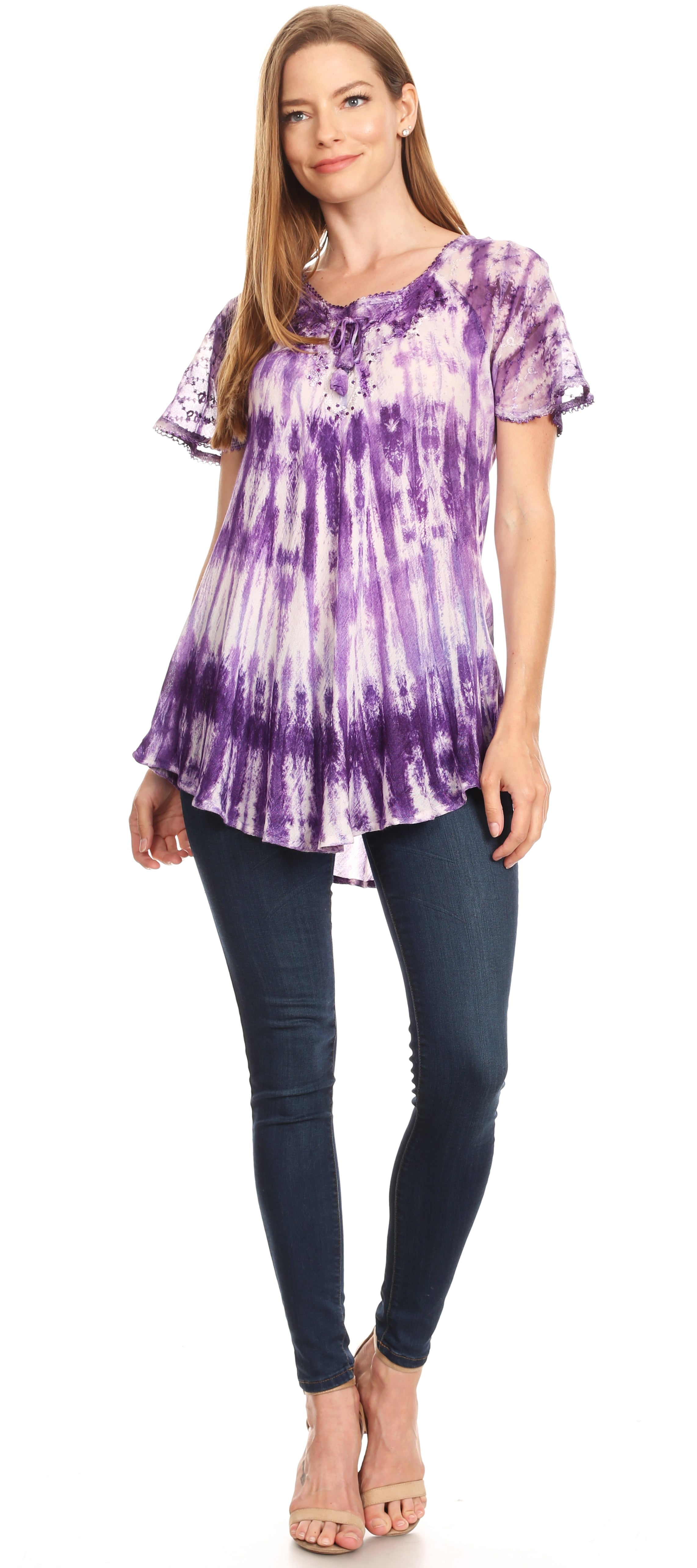 Woman wearing a purple tie-dye shirt and dark jeans on a white background