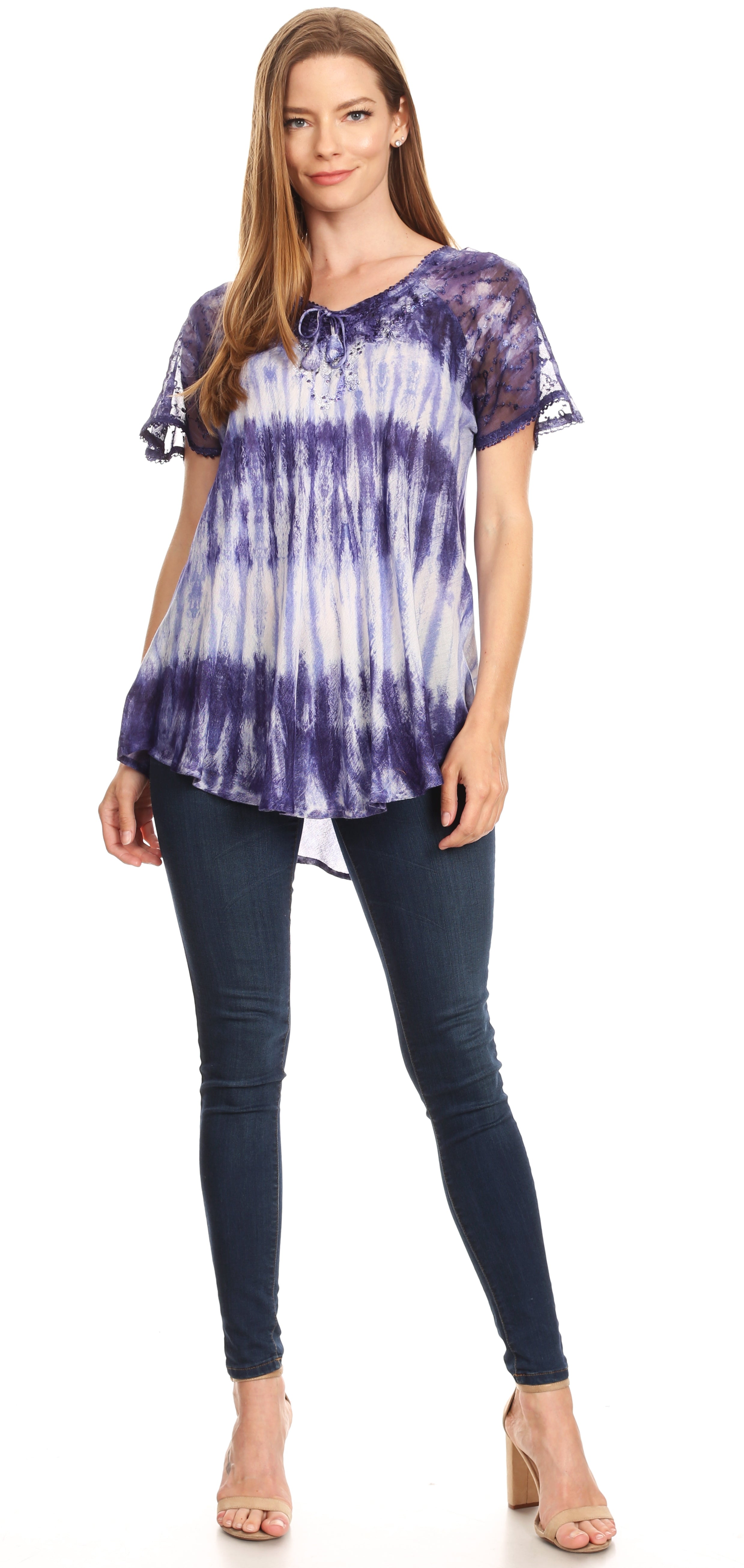 Woman wearing a purple tie-dye top and dark jeans on a white background